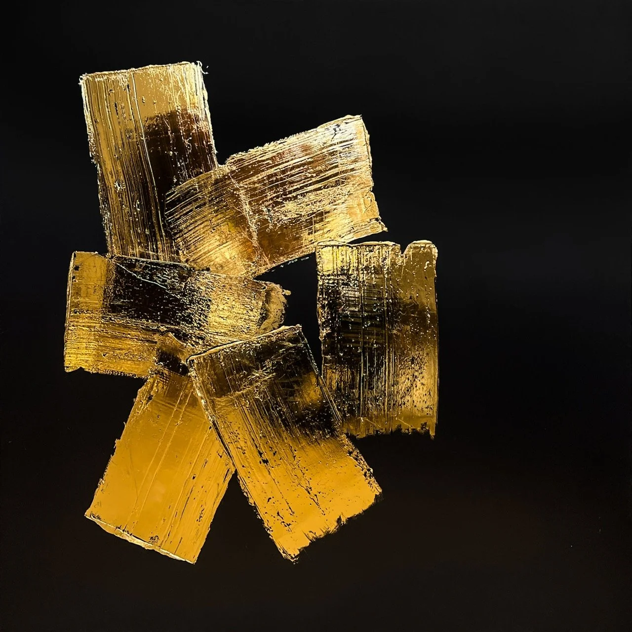 Close-up of several golden, translucent crystals with sharp edges on a black background.