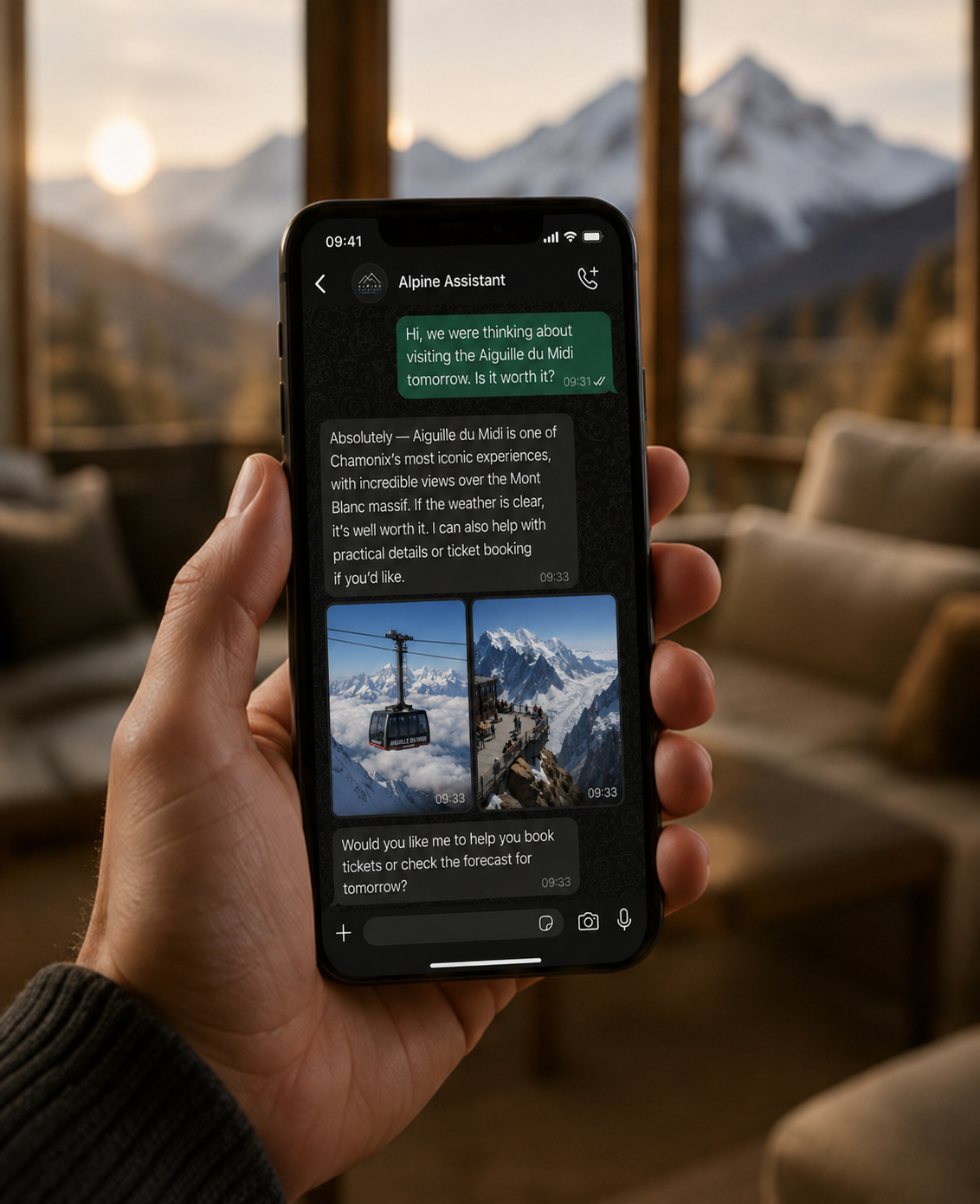 Person holding a smartphone with a chat conversation about visiting Aiguille du Midi in Chamonix, France, with mountain photos in the background and snow-capped peaks visible through the window.
