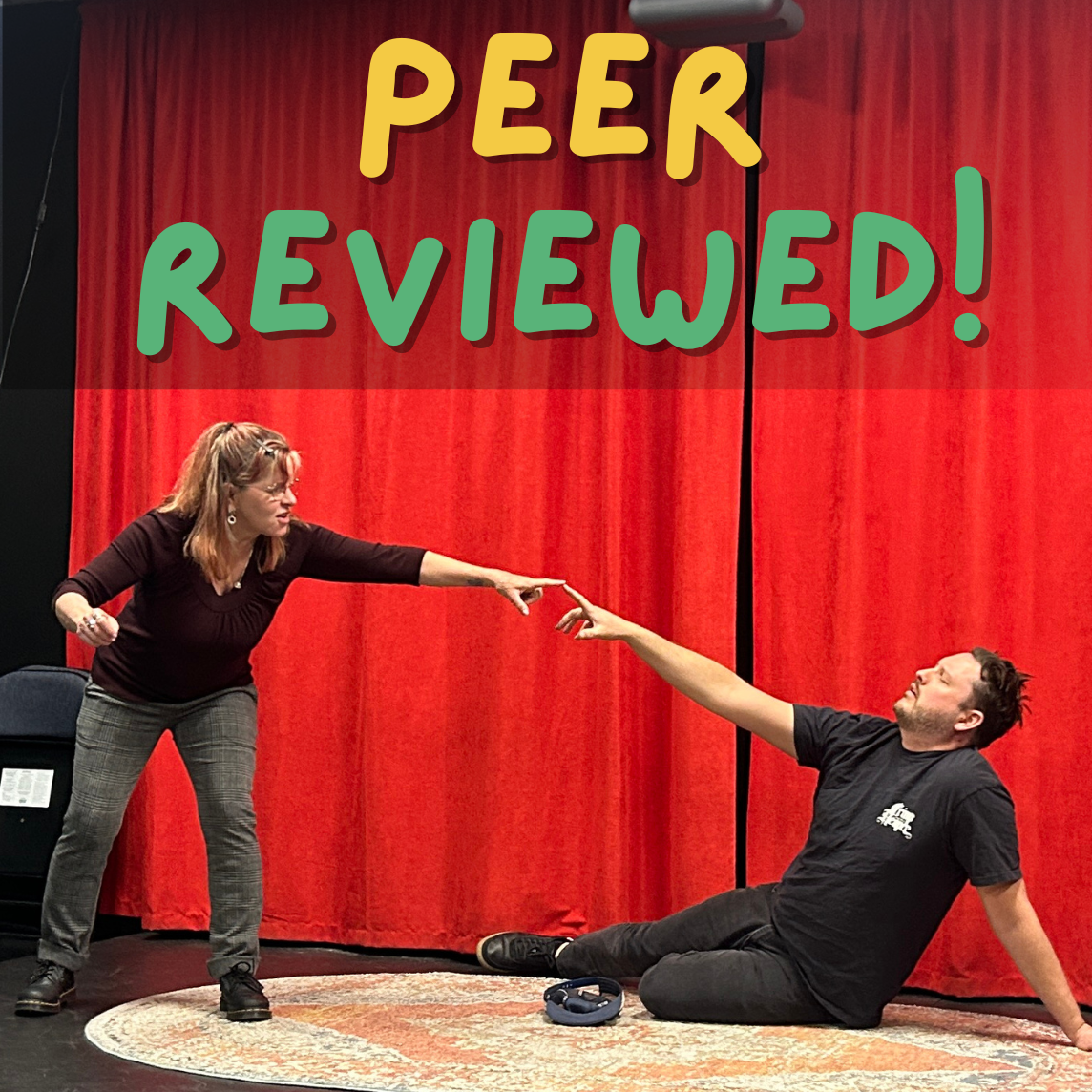 A woman in a black top and plaid pants reaching out to a man in black t-shirt and dark pants, who is sitting on the floor and reaching back towards her, with a red curtain backdrop and a sign that says 'PEER REVIEWED!' in colorful letters overhead.