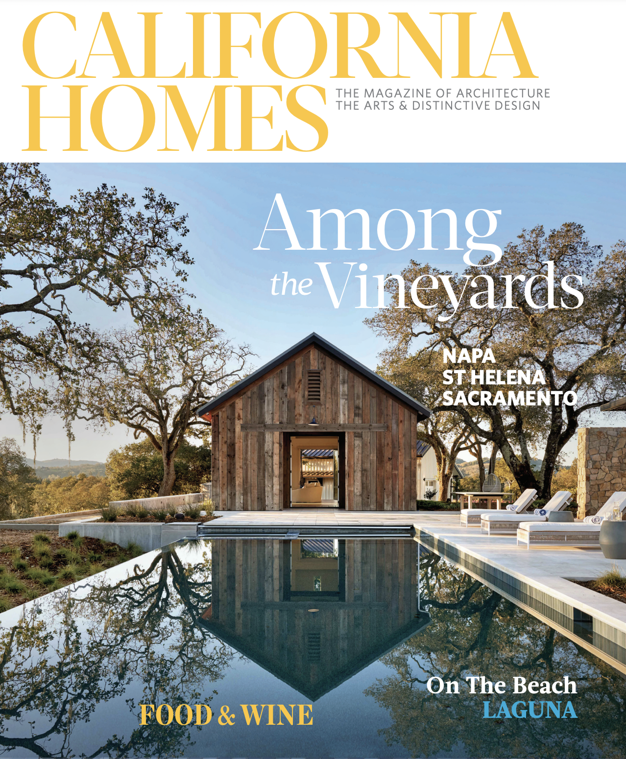 Cover of California Homes magazine featuring a wooden house by a swimming pool with reflections of trees and the house, in a vineyard setting during daytime.