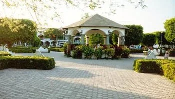 A public park area with a pavilion, surrounded by trees and benches.