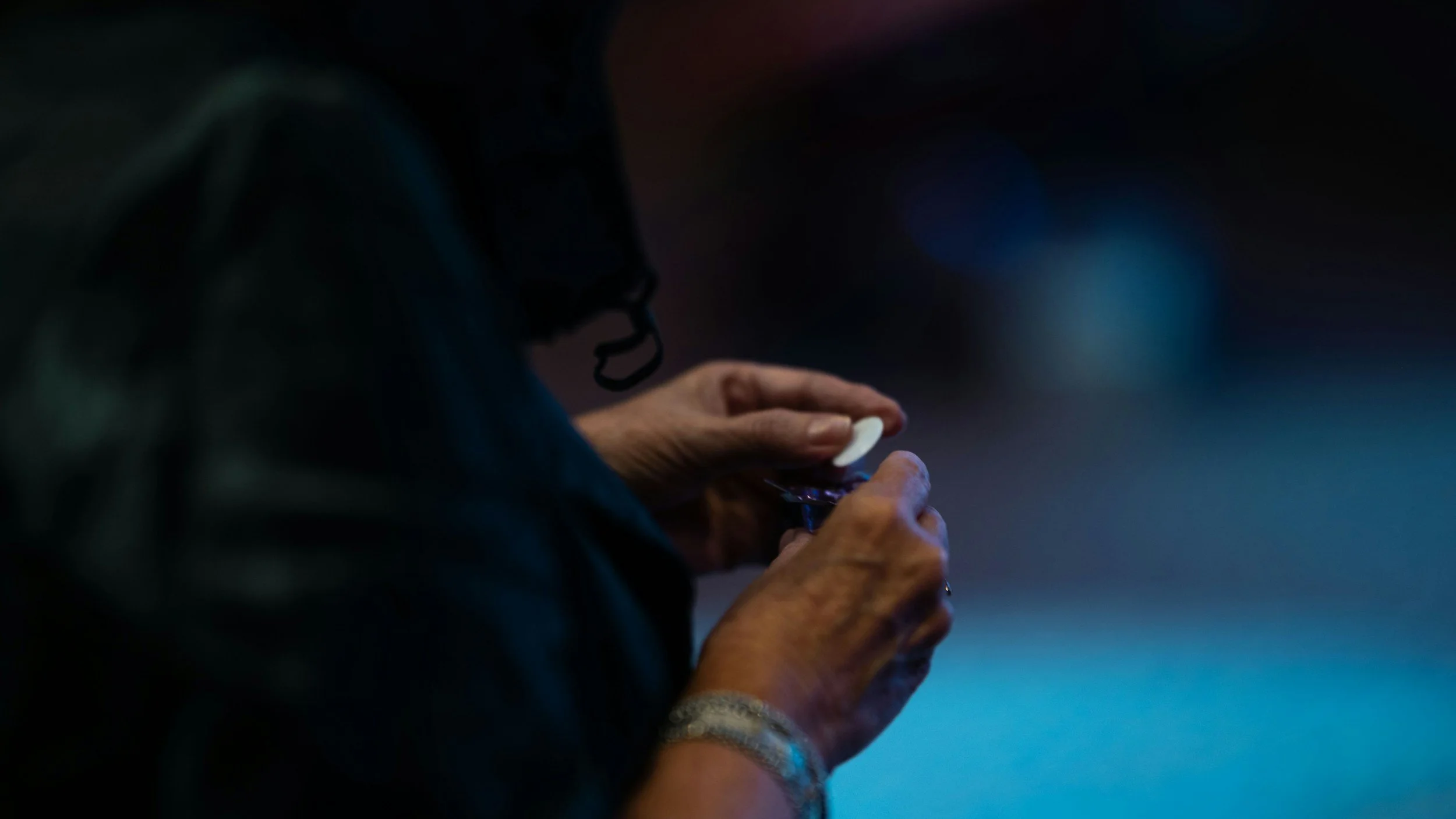 Close-up of a person using a smartphone at night in a dimly lit environment.