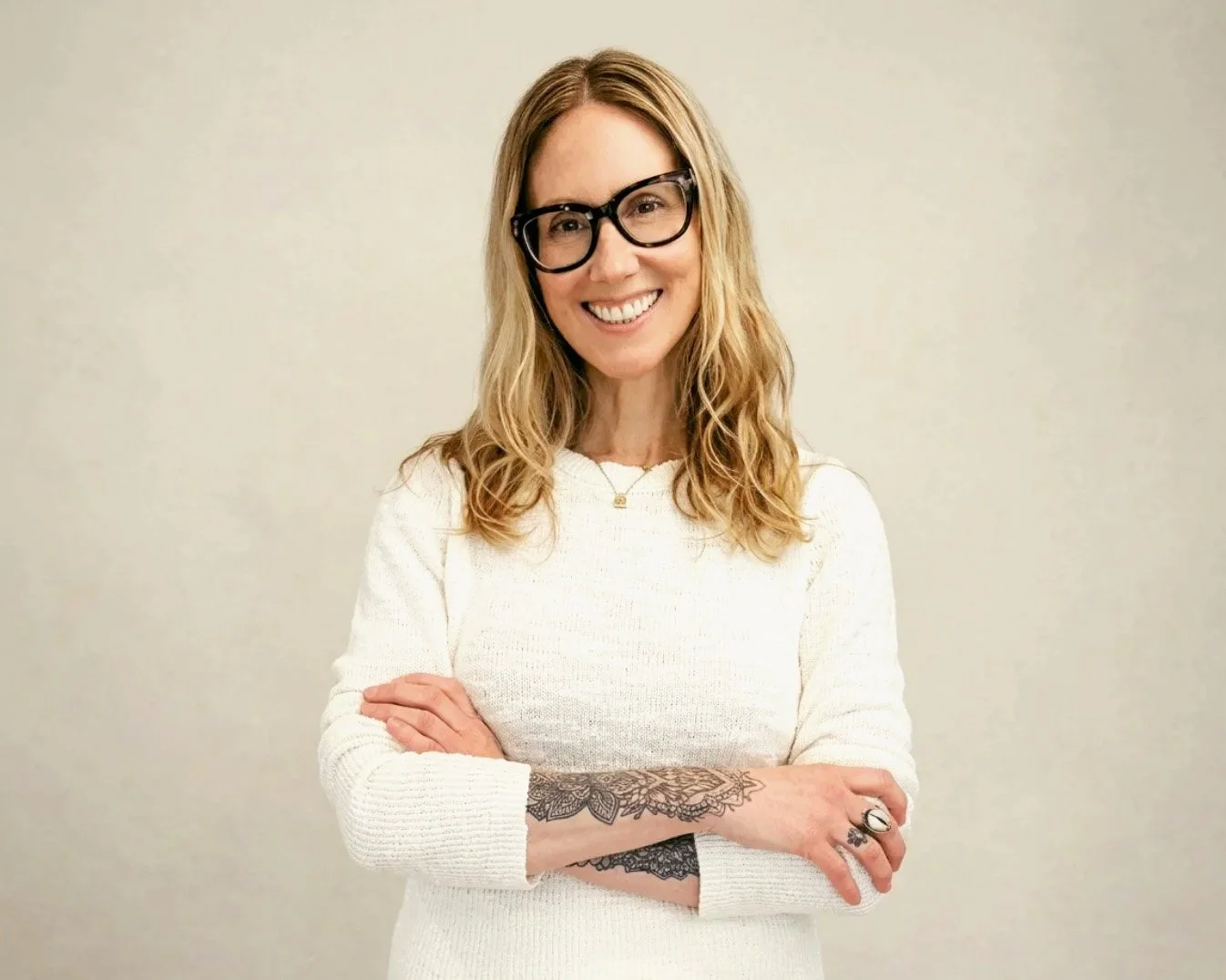 Kelly Chapman, LCSW, psychotherapist in Long Beach, NY, standing with arms crossed and smiling.