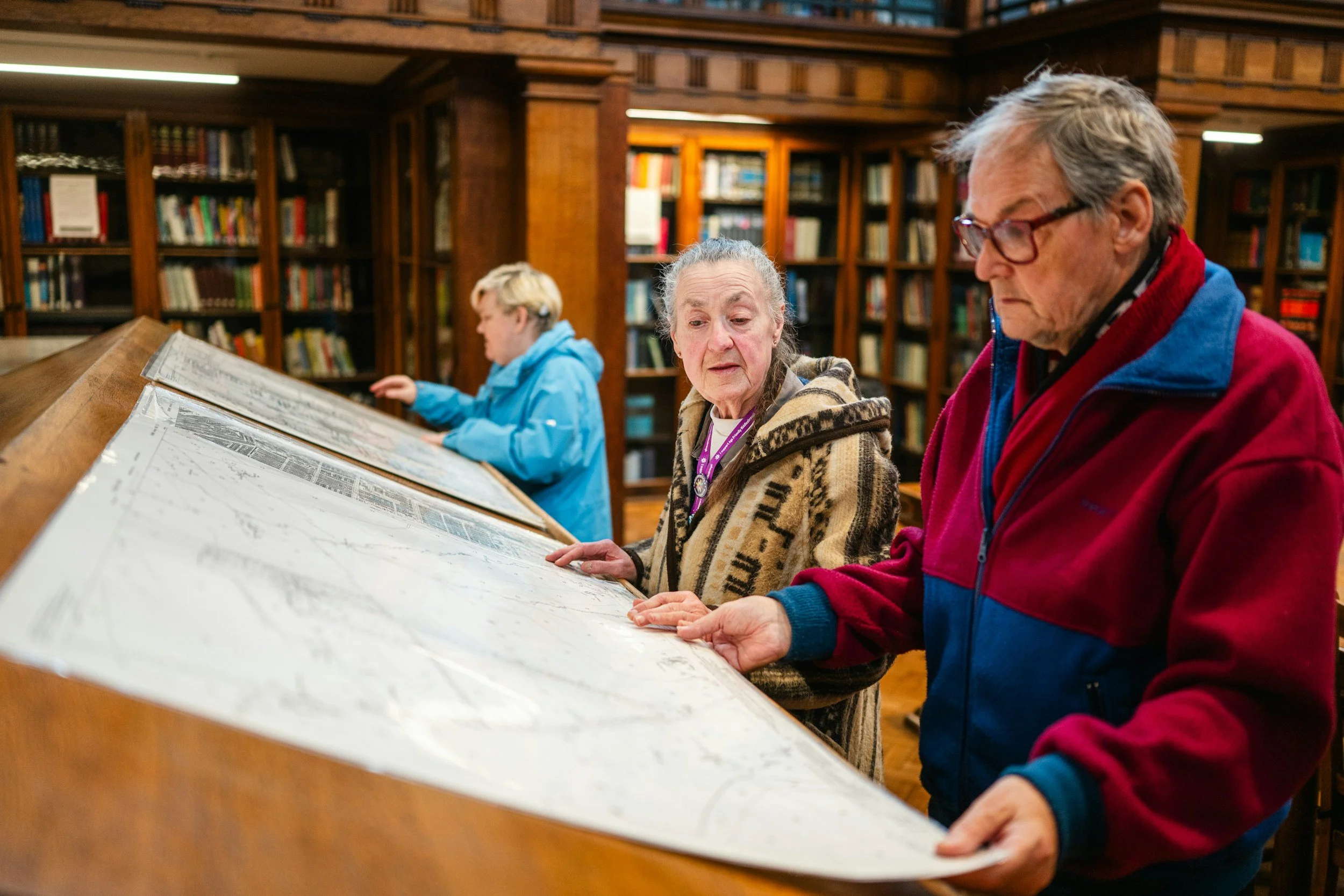 people viewing a physical map in a library