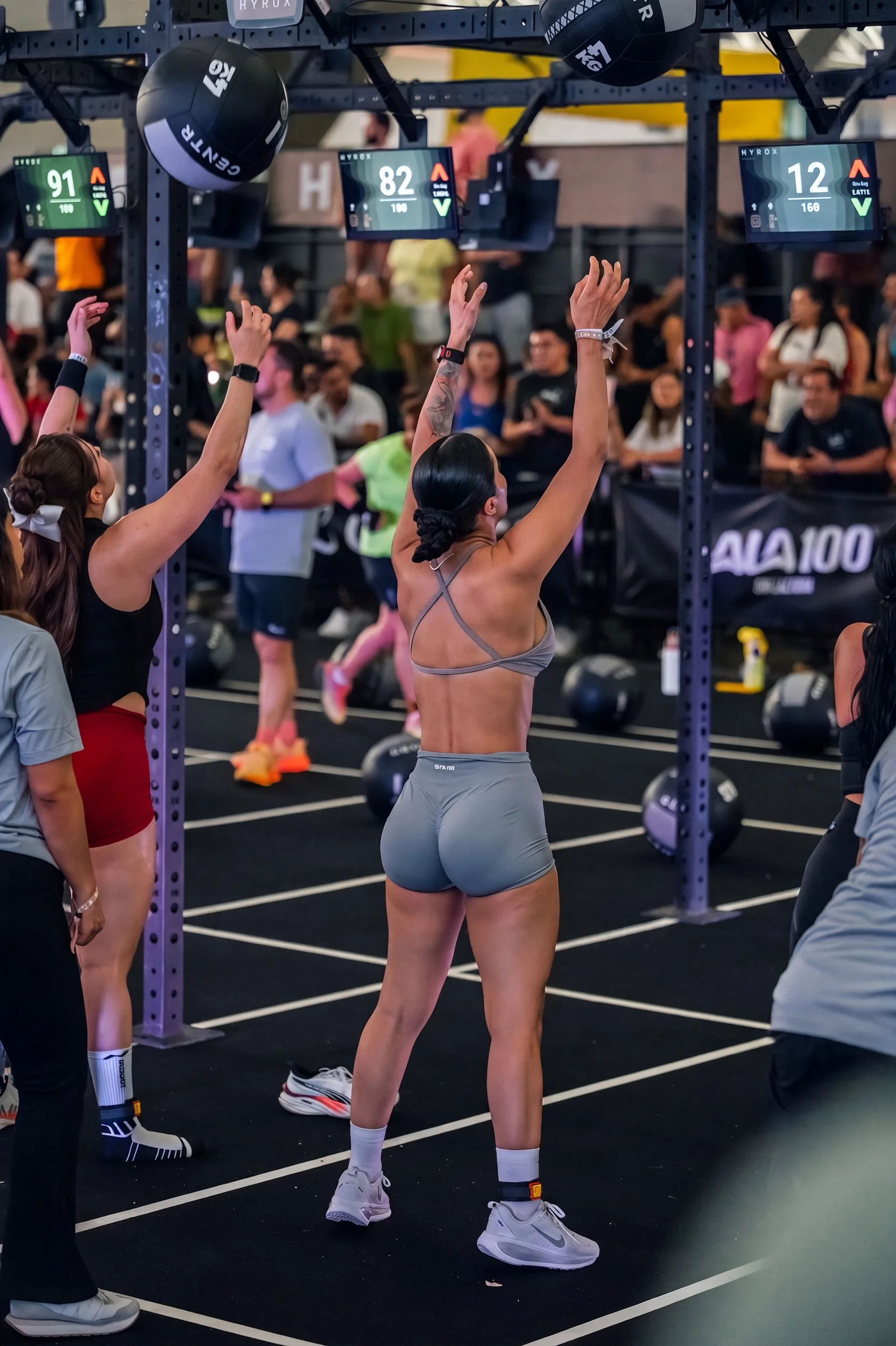 Dos mujeres levantando las manos durante entrenamiento funcional en gimnasio, fotografía fitness por Carlos Vega en Hyrox Puebla.