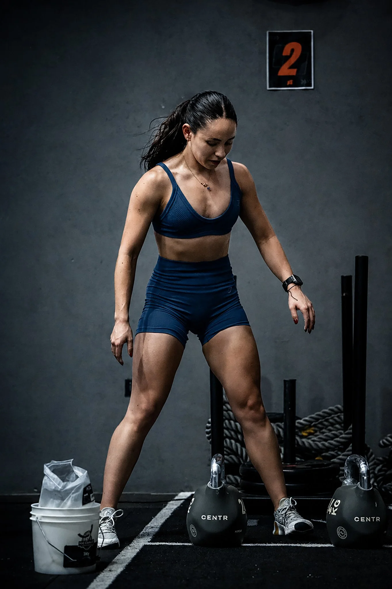 Mujer entrenando con pesas en gimnasio, fotografía fitness profesional por Carlos Vega en Puebla.