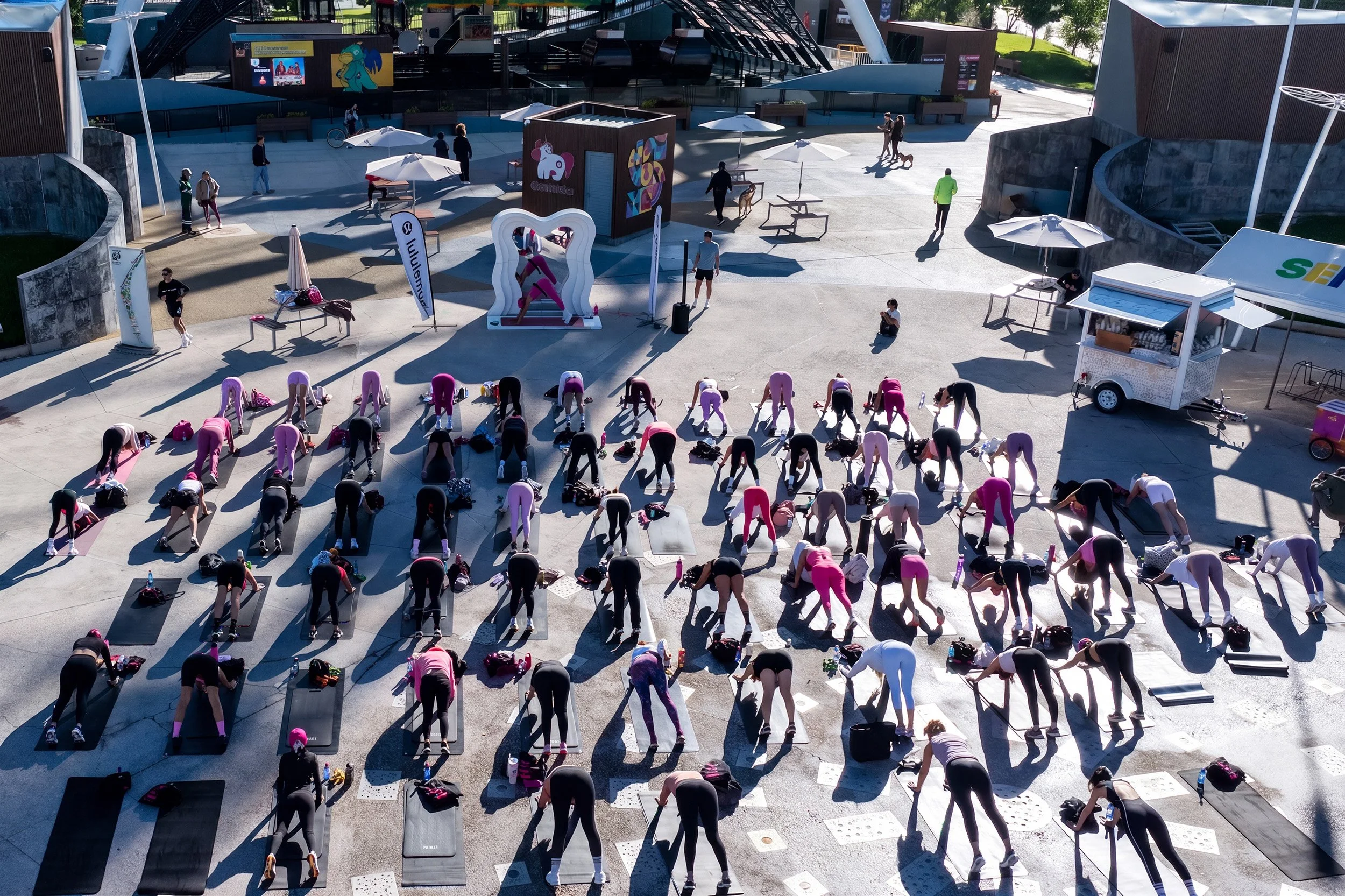 Clase masiva de yoga al aire libre en evento wellness, fotografía con drone por Carlos Vega.
