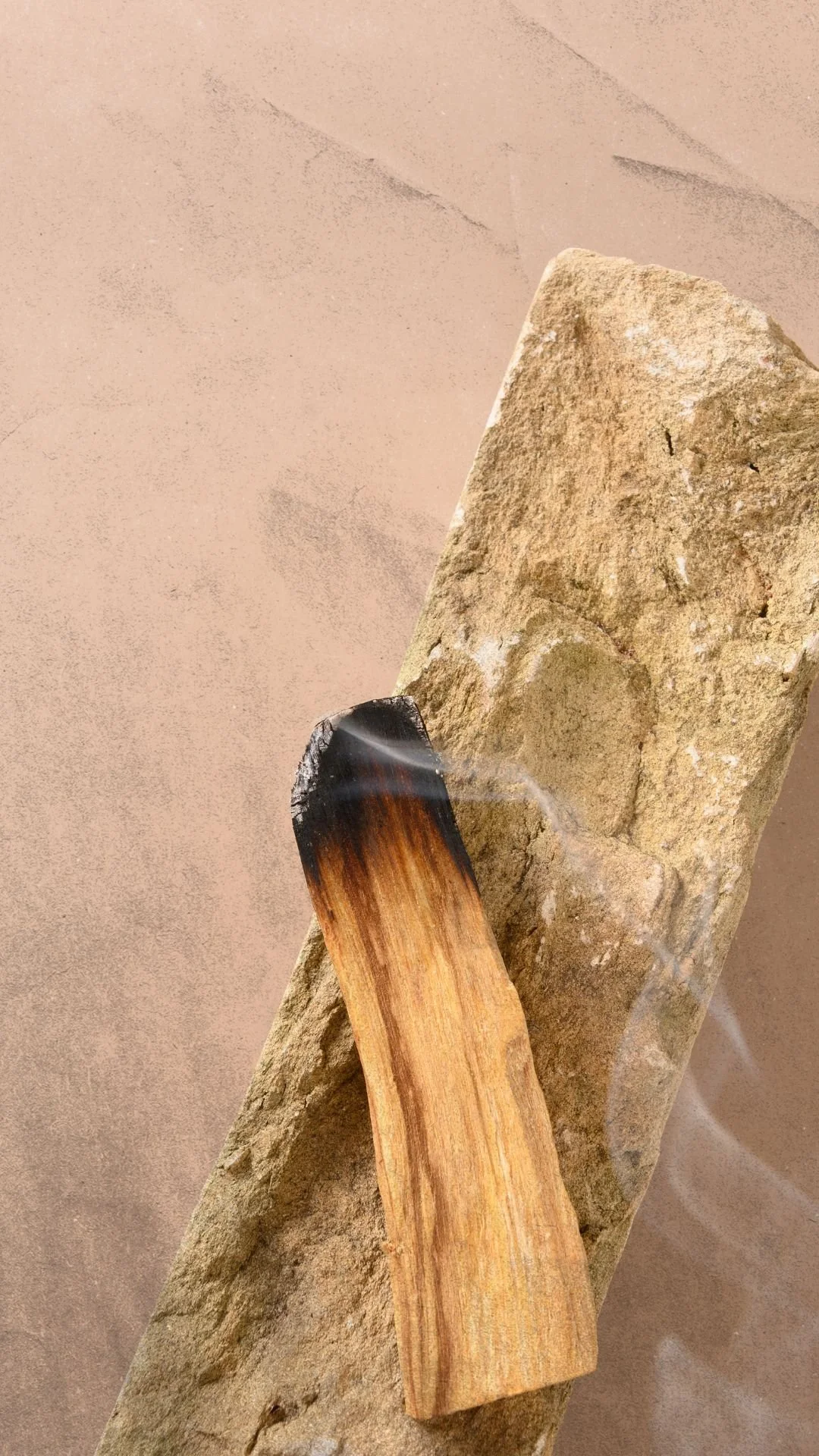 Palo santo smoke rising beside a natural stone during a grounding ritual in Grapevine, Texas.