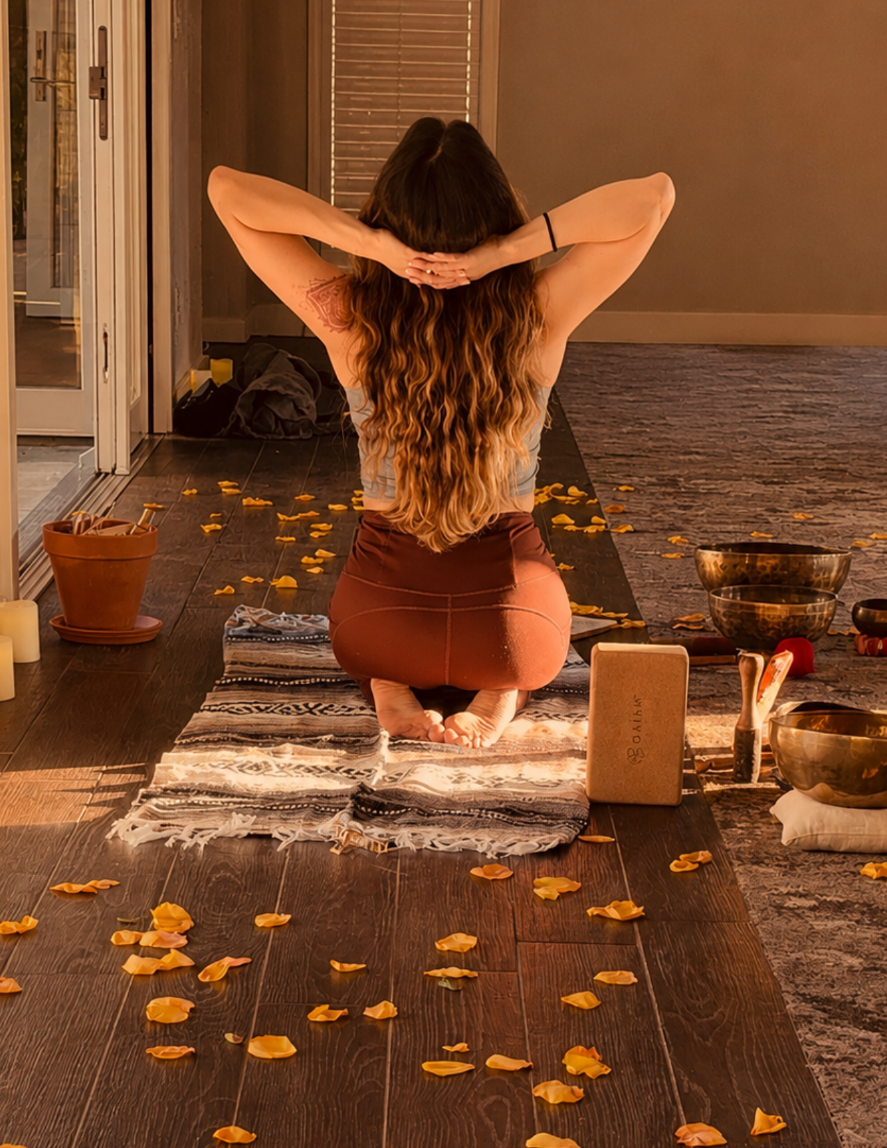 Yoga instructor Samantha Matta seated beside yoga props and sound bowls during a mindful movement practice.