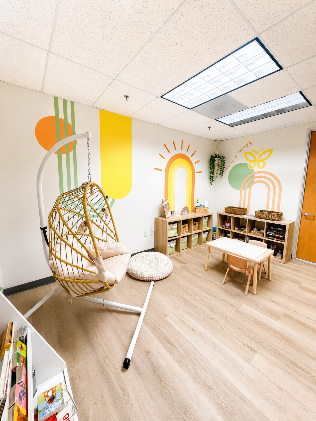 Bright sensory-friendly pediatric therapy room with calming décor, child-sized furniture, and therapeutic play equipment at Monarch Developmental Services.