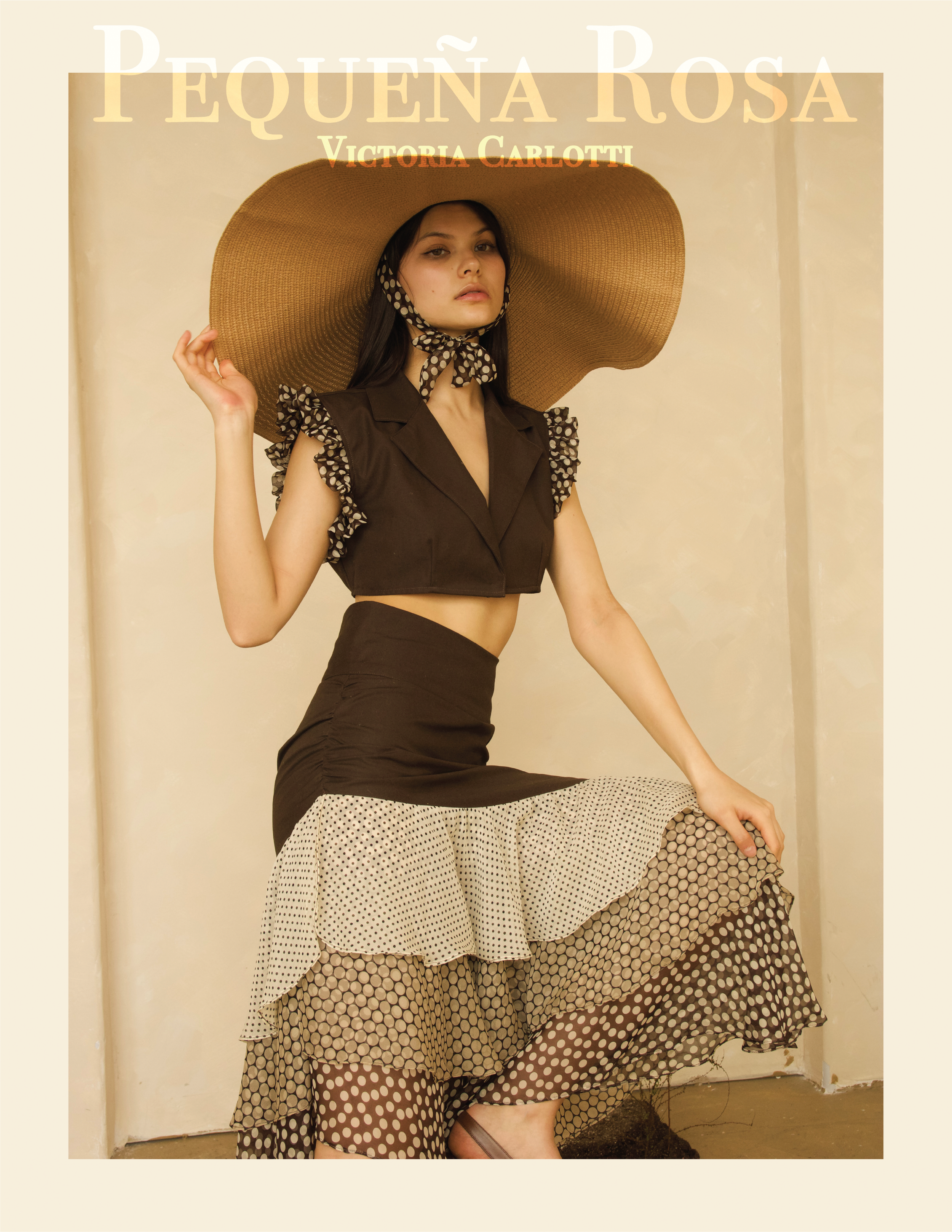 A woman dressed in vintage-inspired fashion, wearing a large straw hat with a polka dot scarf, a sleeveless blouse with ruffled sleeves, a polka dot skirt with layered ruffles, and polka dot stockings, positioned indoors against a plain beige wall.