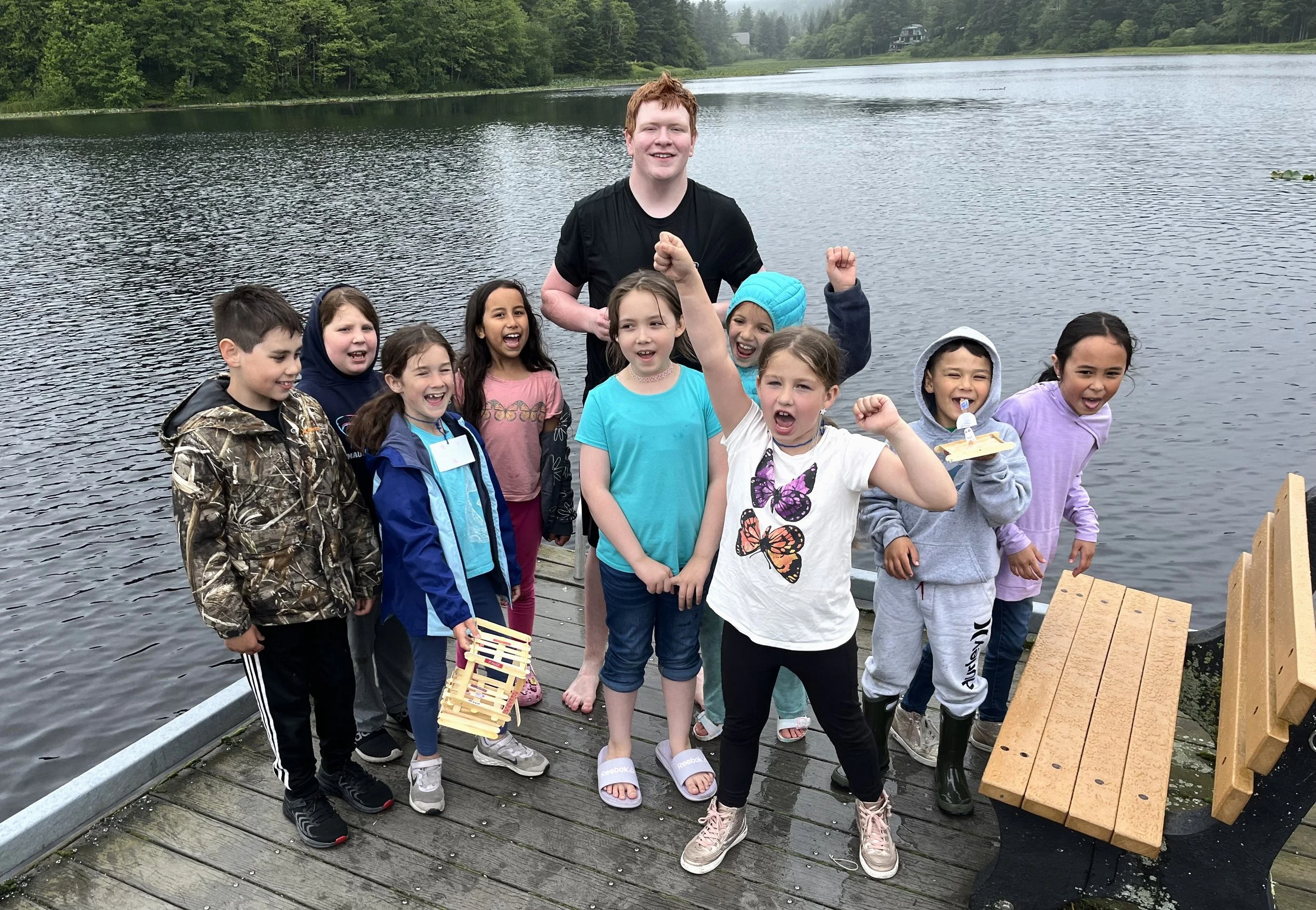 Youth at swan lake in Sitka floating boats as part of recreational programming.