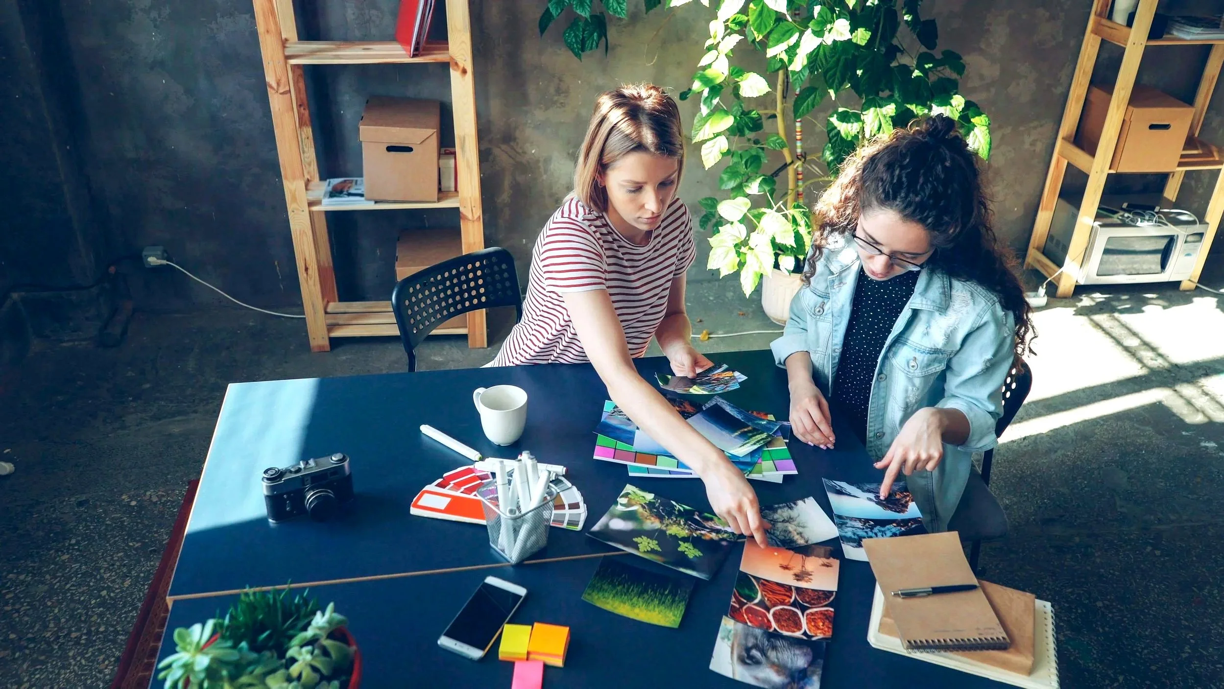 Two people reviewing print samples and color proofs at a design table