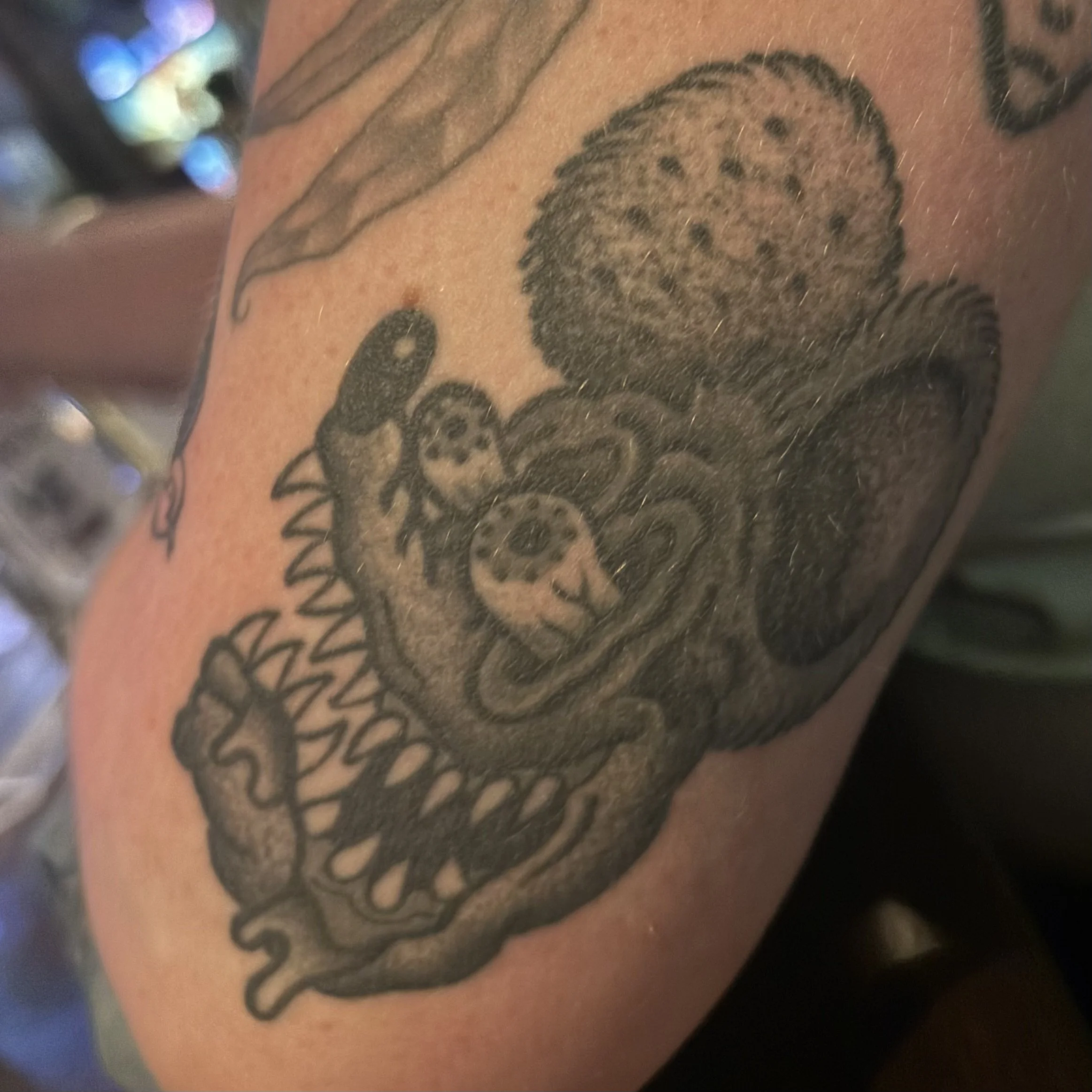 healed black and gray Rat Fink tattoo