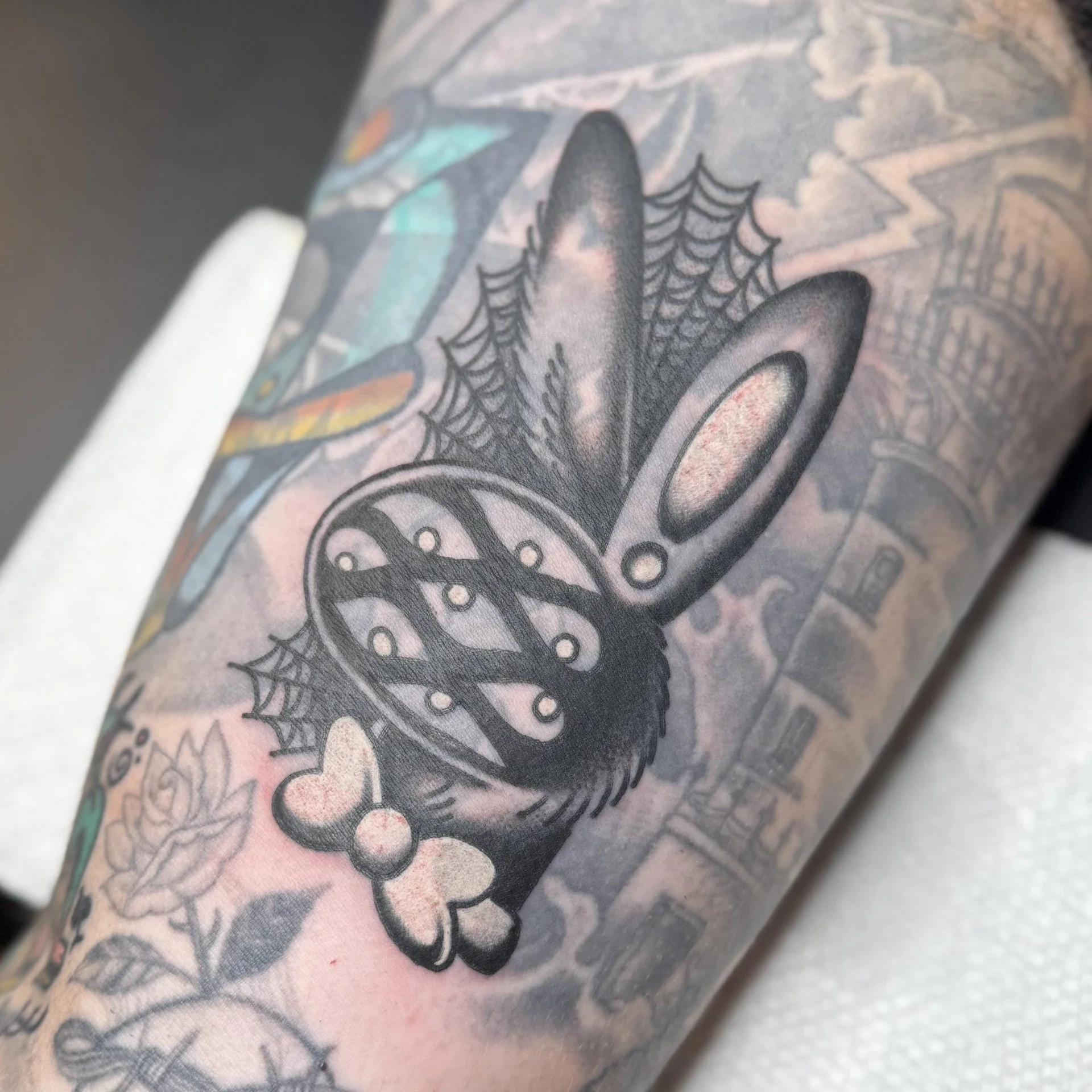 Blackwork blastover tattoo of a Playboy Bunny with multiple eyeballs