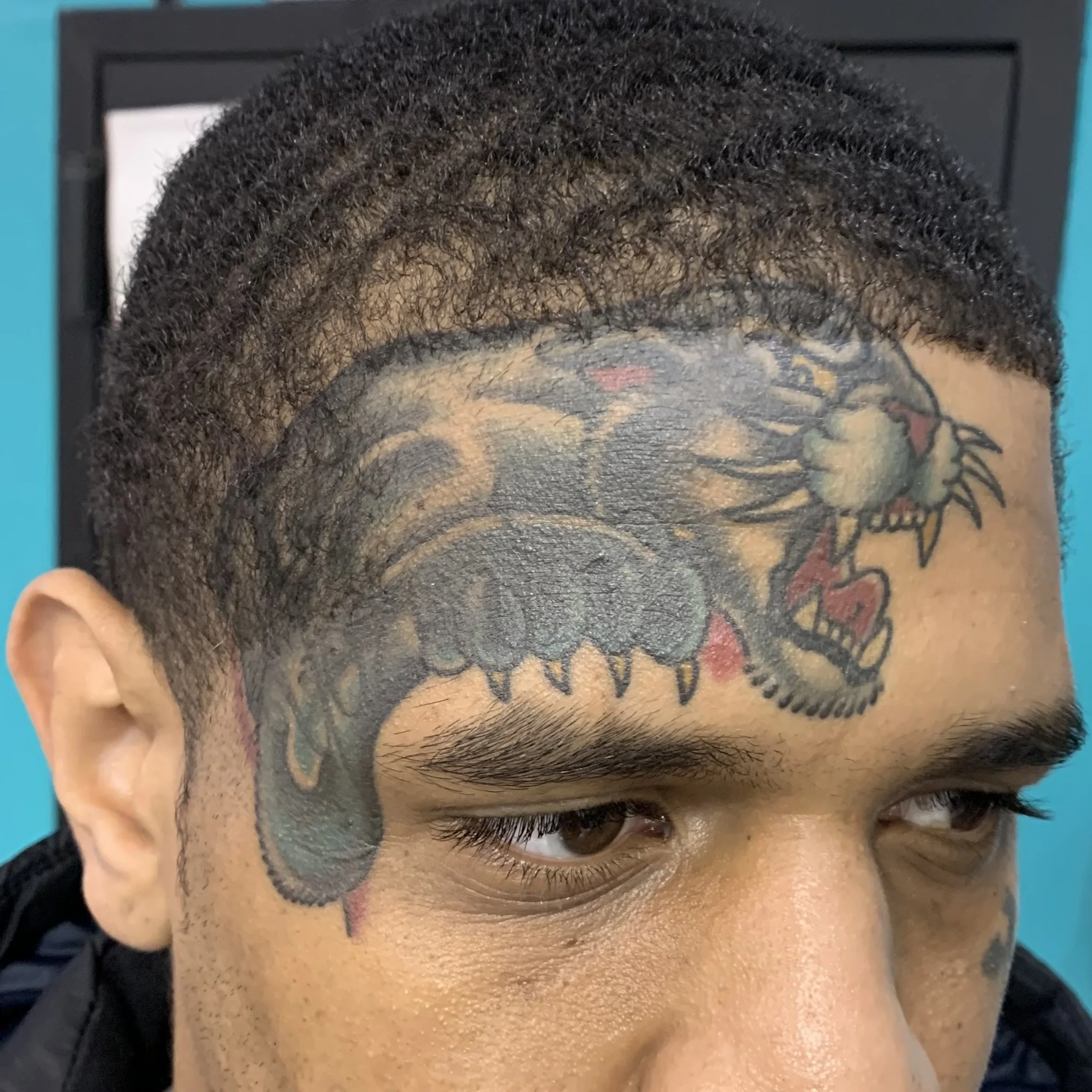 Panther tattoo covering a name on a face