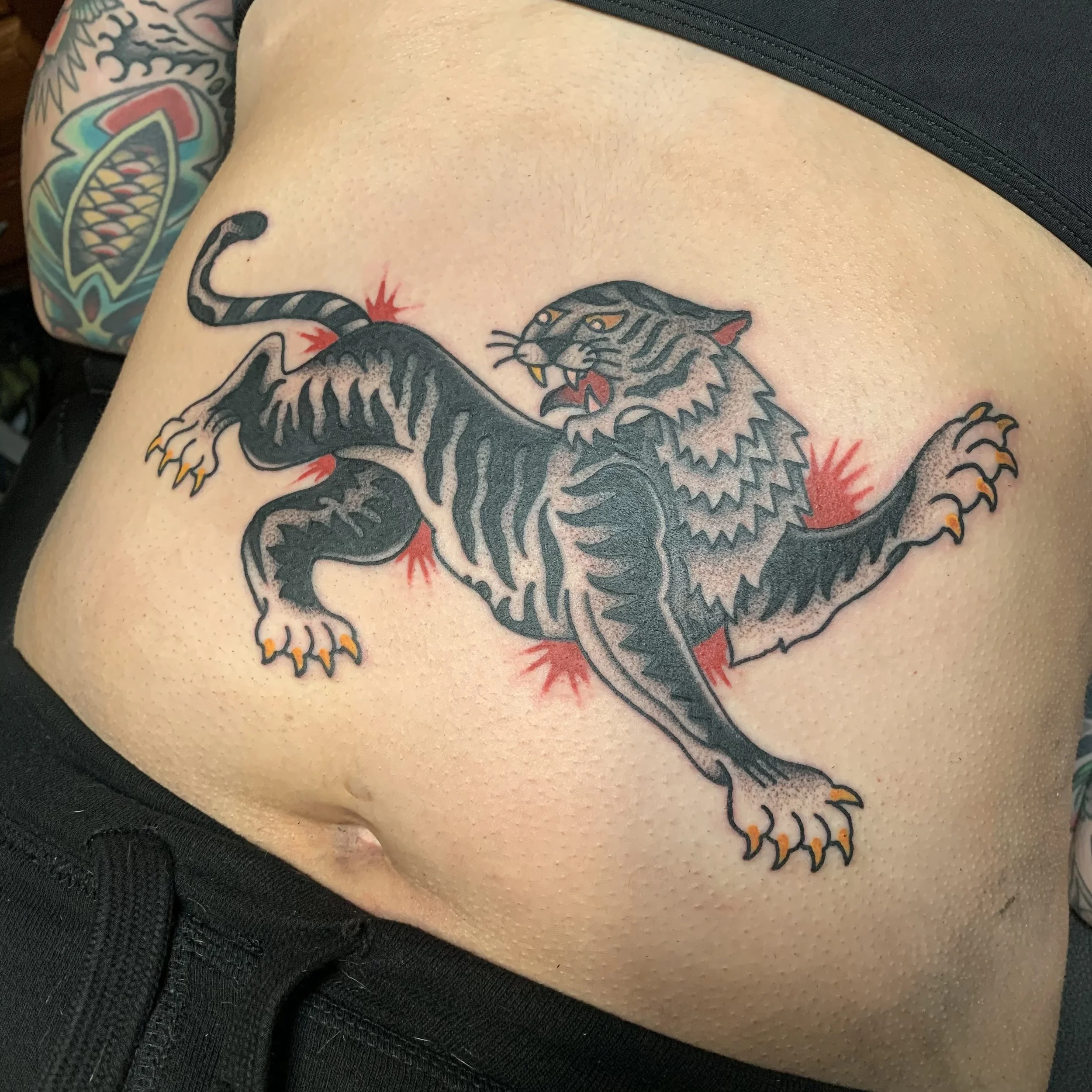 Traditional Tiger tattoo done in Blackwork/Dotwork with a splash of red on a stomach