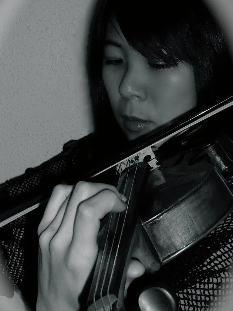 Ms. Yuko Saito: A woman with black hair playing a violin.