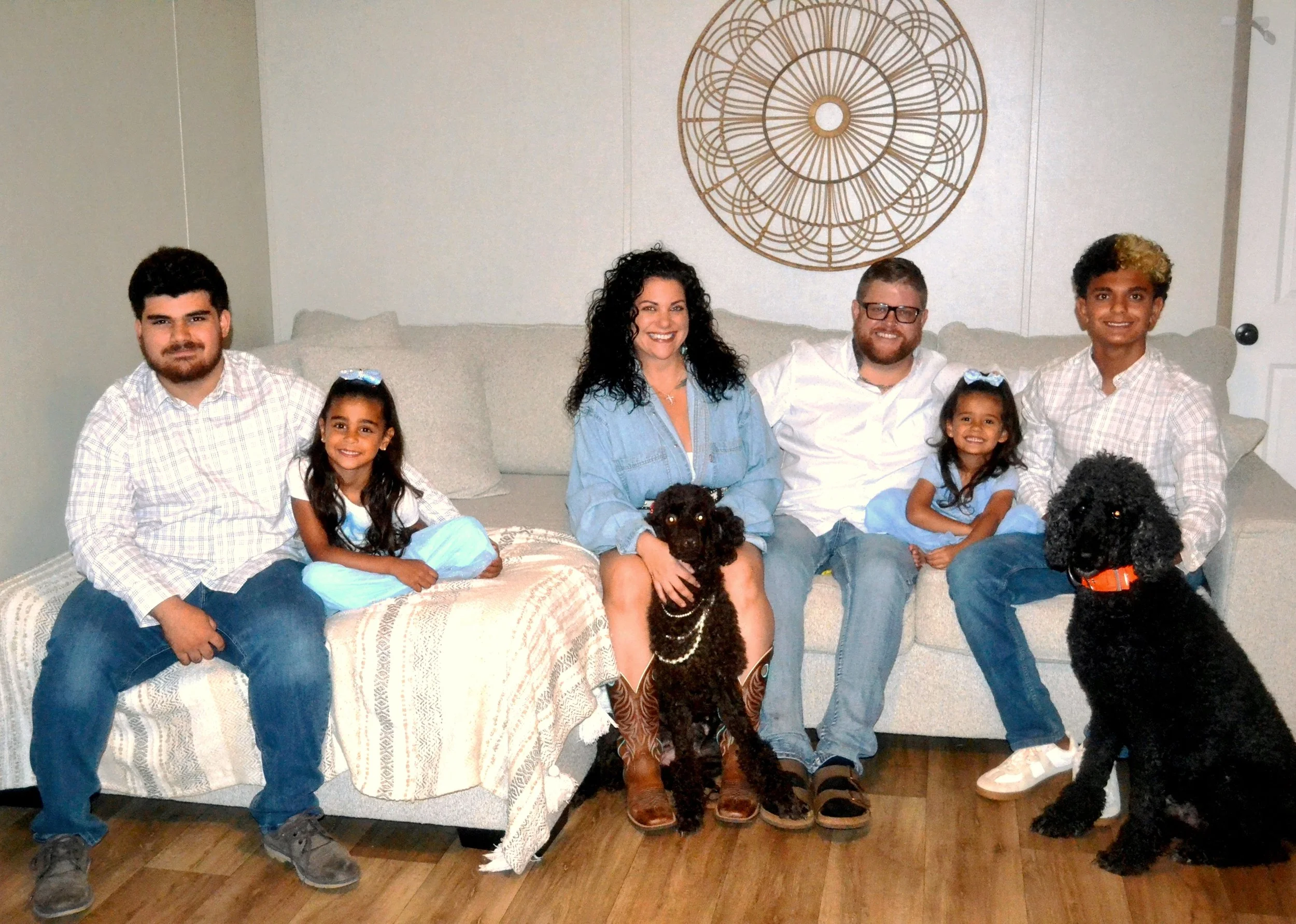 Family of two teenage boys, two little girls, middle-aged woman and man with two adult poodles.