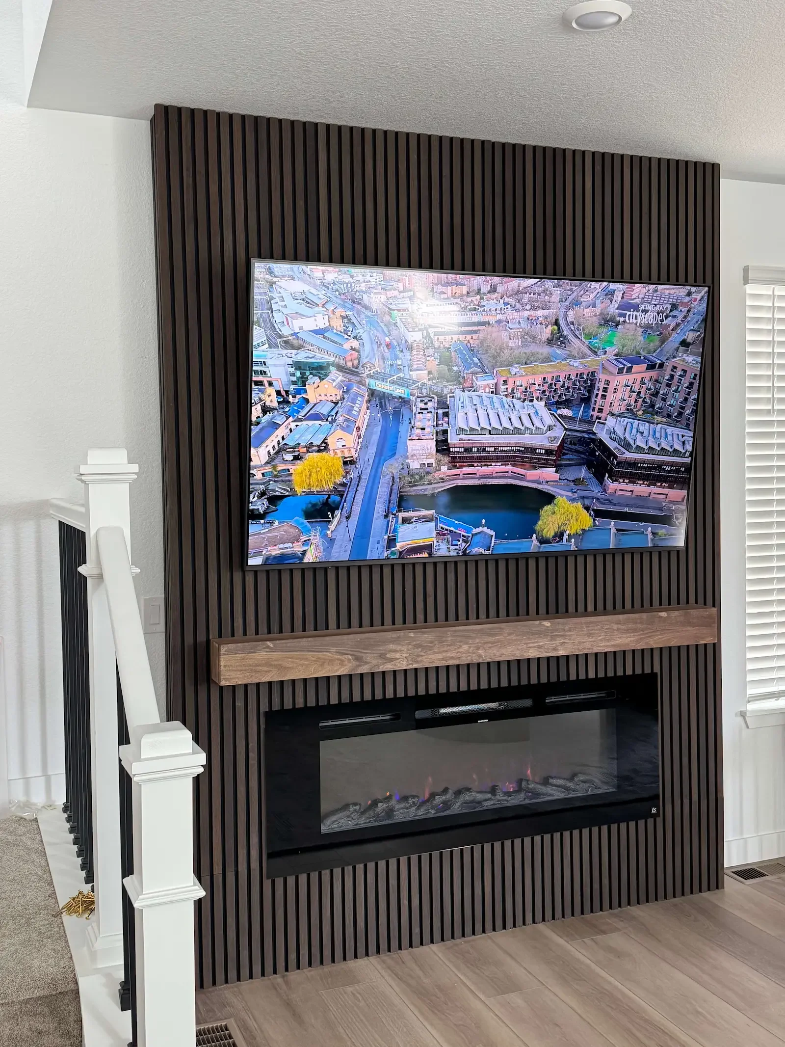 Custom wood slat media wall with TV and electric fireplace in a Denver home