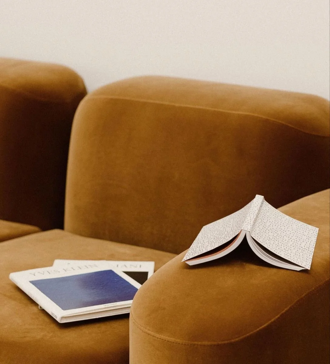 An open notebook with a dotted pattern on the right armrest of a brown, upholstered chair.