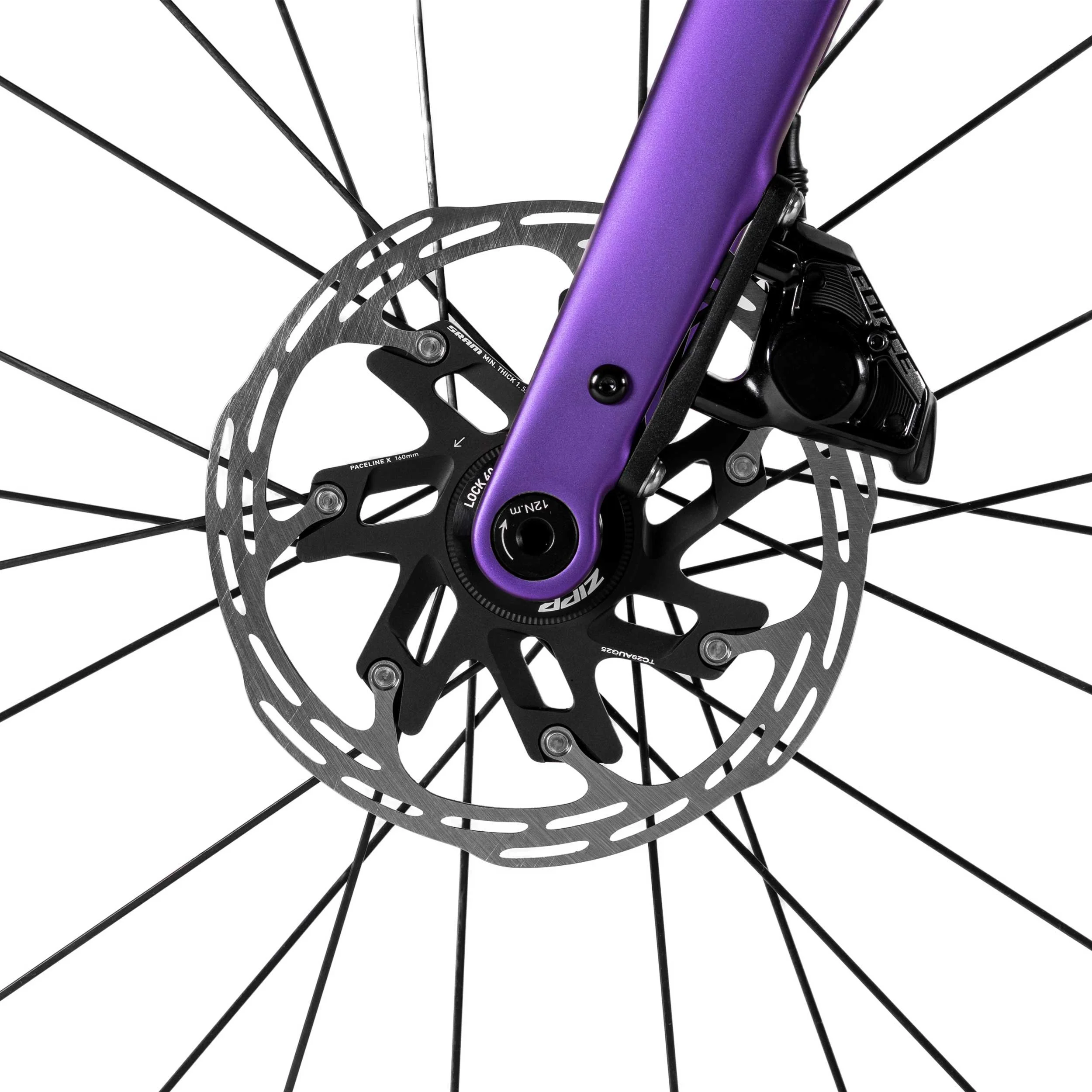 Nahaufnahme eines Fahrrad-Hinterrades mit schwarzem Reifen, schwarzen Speichen, einer rotierenden Scheibenbremse und einer purple Gabel.
