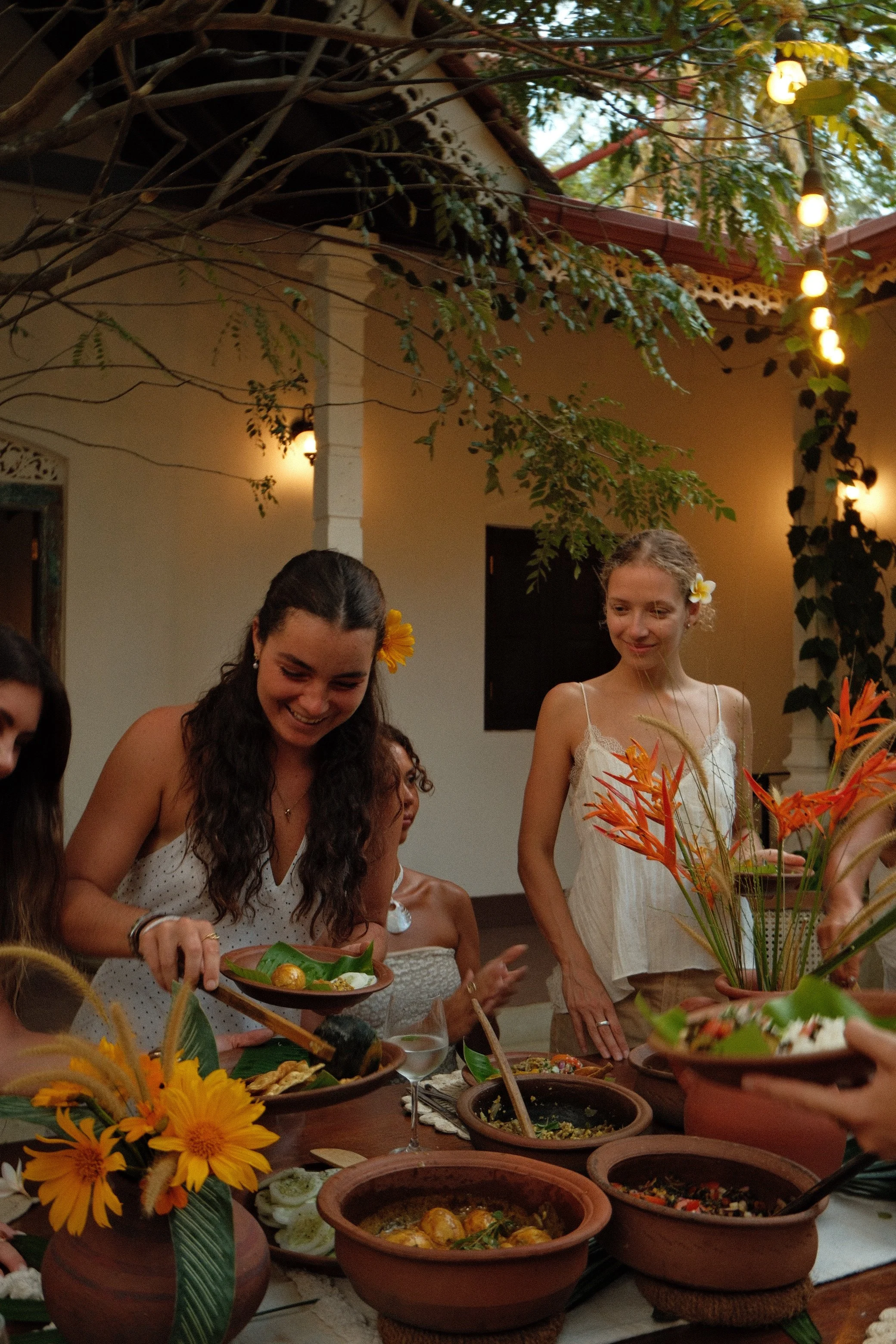 People at a gathering enjoying food and drinks in a outdoor setting.
