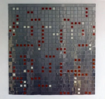 A mosaic wall with a pattern of small red, white, and gray tiles arranged in abstract design.