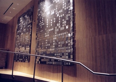 Decorative wall with square metal panels in a modern interior space.