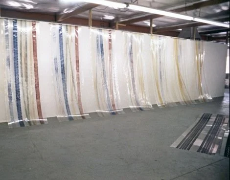 Large roll of patterned wallpaper hanging in a store or warehouse.