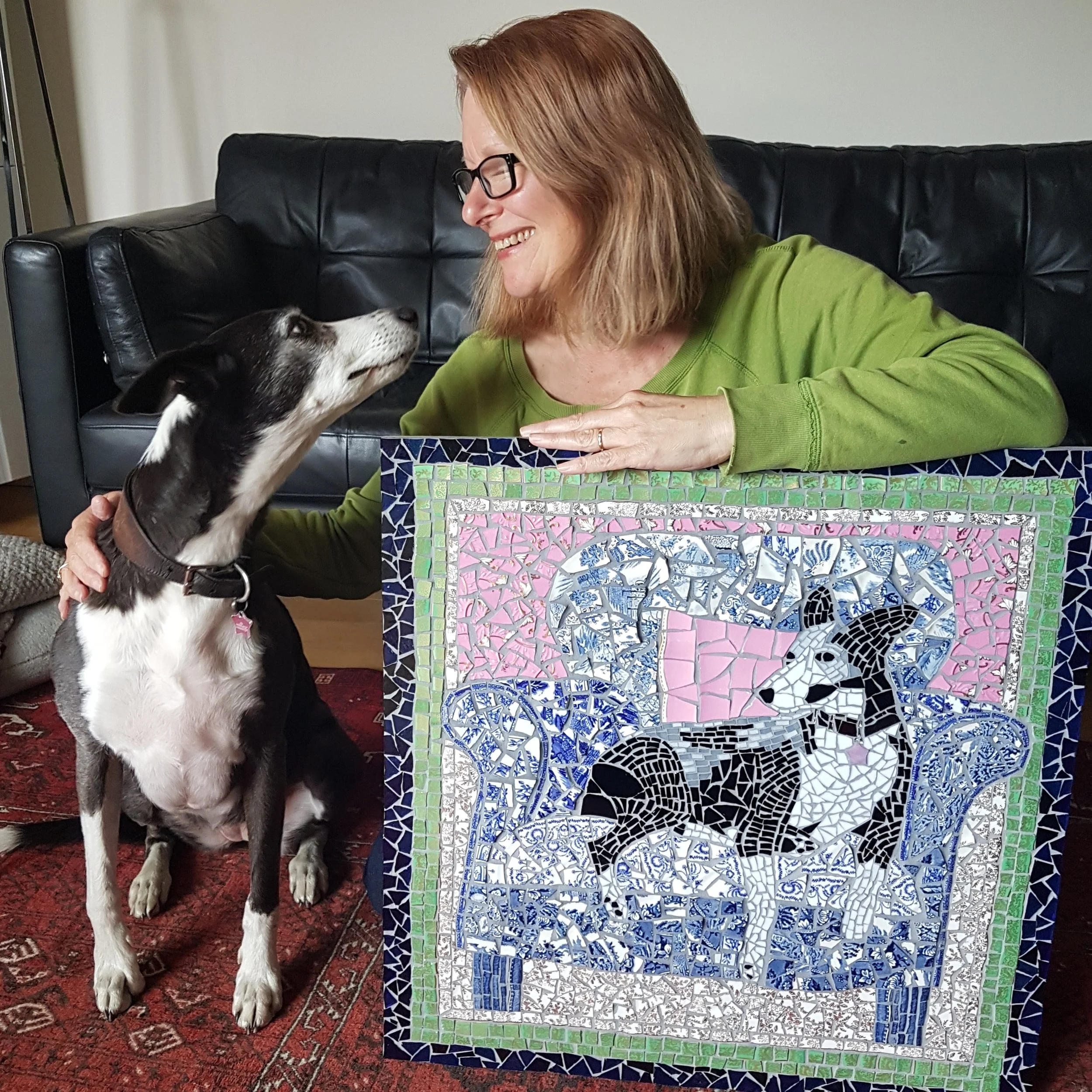 Jacky and her dog, Pip posing with a mosaic portrait of Pip.