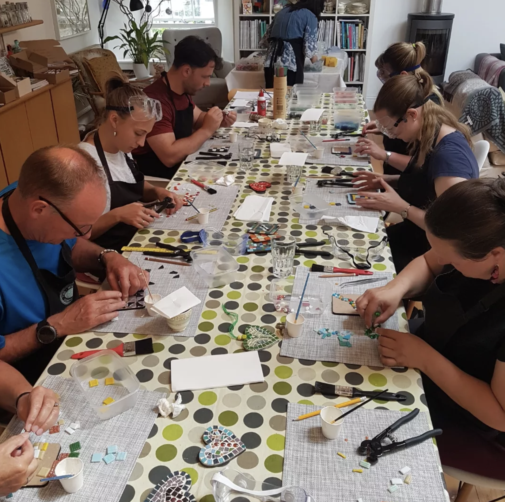 A community workshop with a group making their mosaics around a table