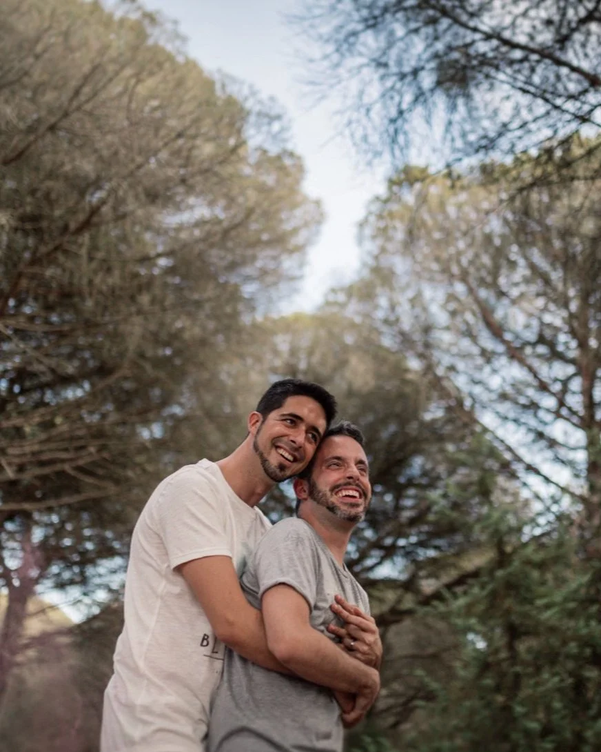 Natural portrait of an LGTBI couple during a pre-wedding photoshoot in the pine forest on the coast of Cádiz, wedding photography in Spain.