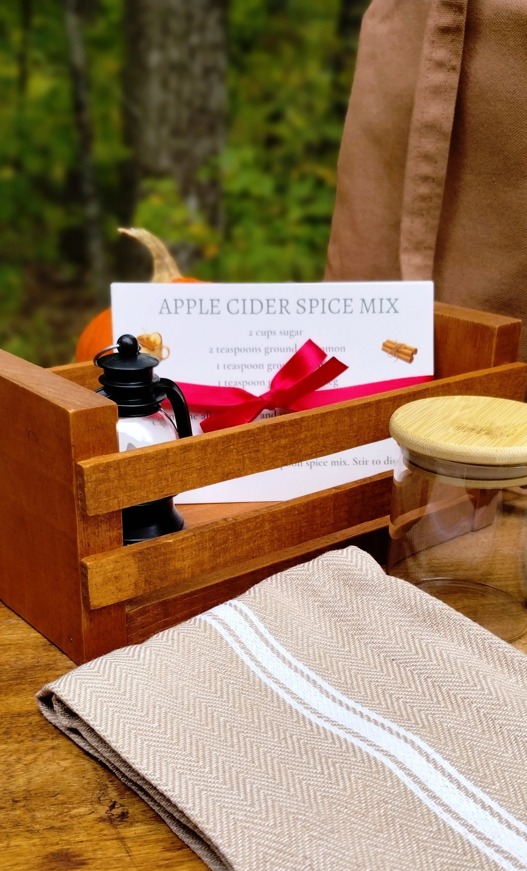 Closeup of hand crafted wooden crate with lantern and recipe cards, and beige kitchen towel