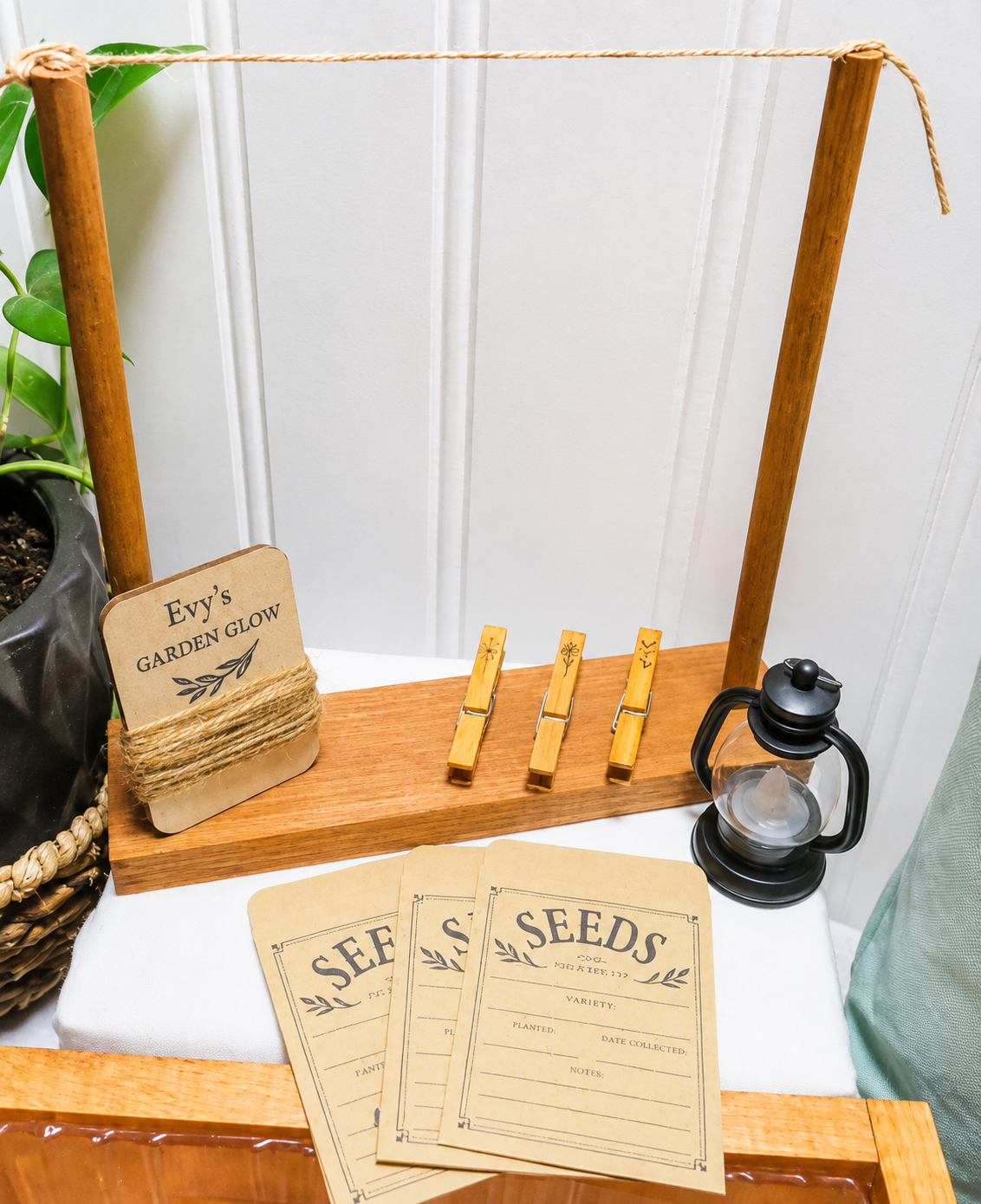 Tabletop herb drying rack, 3 repurposed clothespins, wood tag wrapped with jute twine, 3 seed envelopes, and mini lantern
