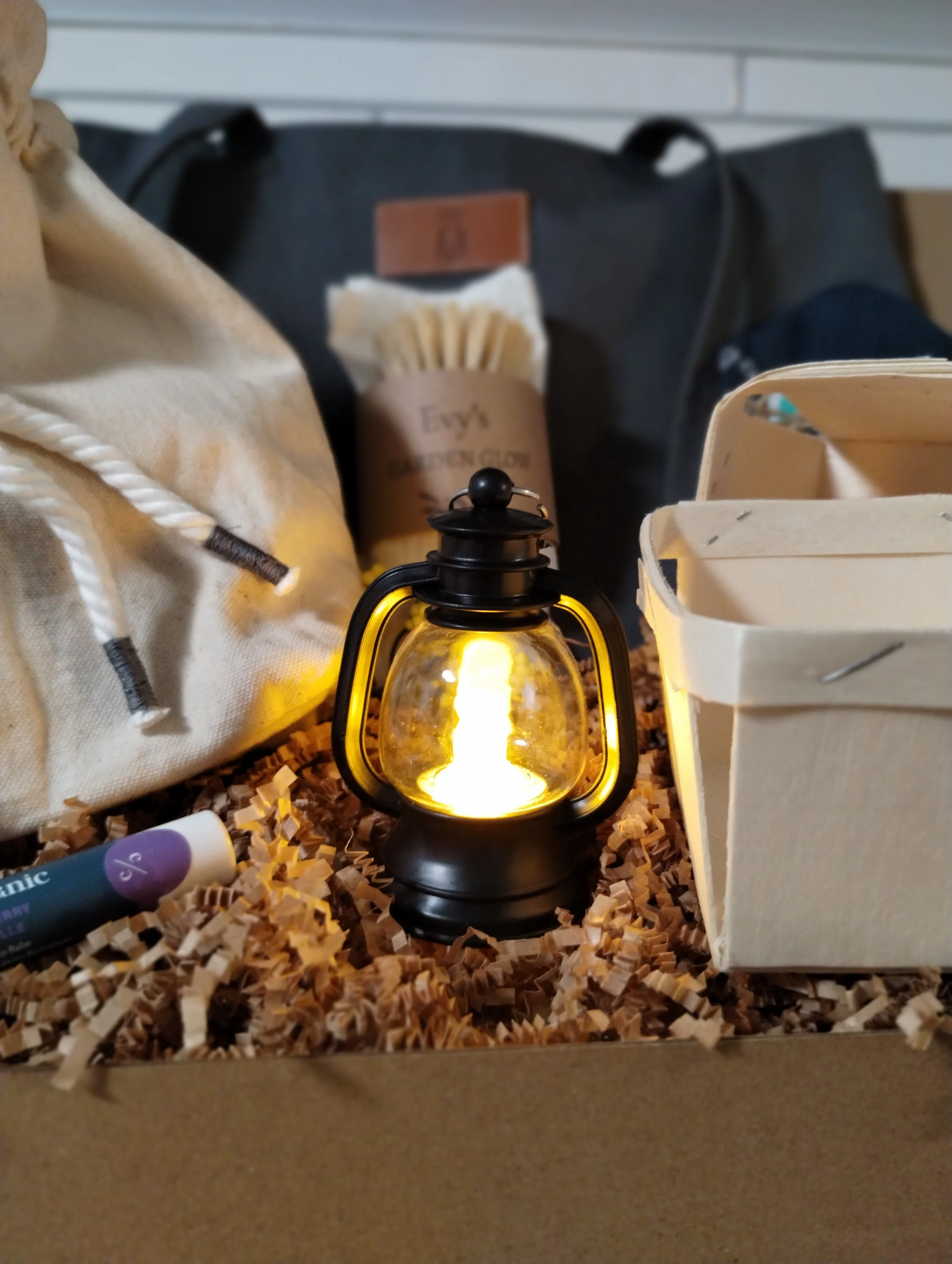 Glowing mini lantern nestled inside the Market Collection gift box with handmade canvas pouch and wooden berry baskets.