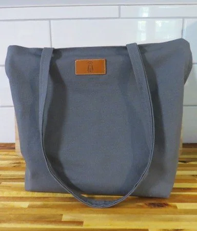 Gray canvas market tote with sturdy handles and spacious interior.