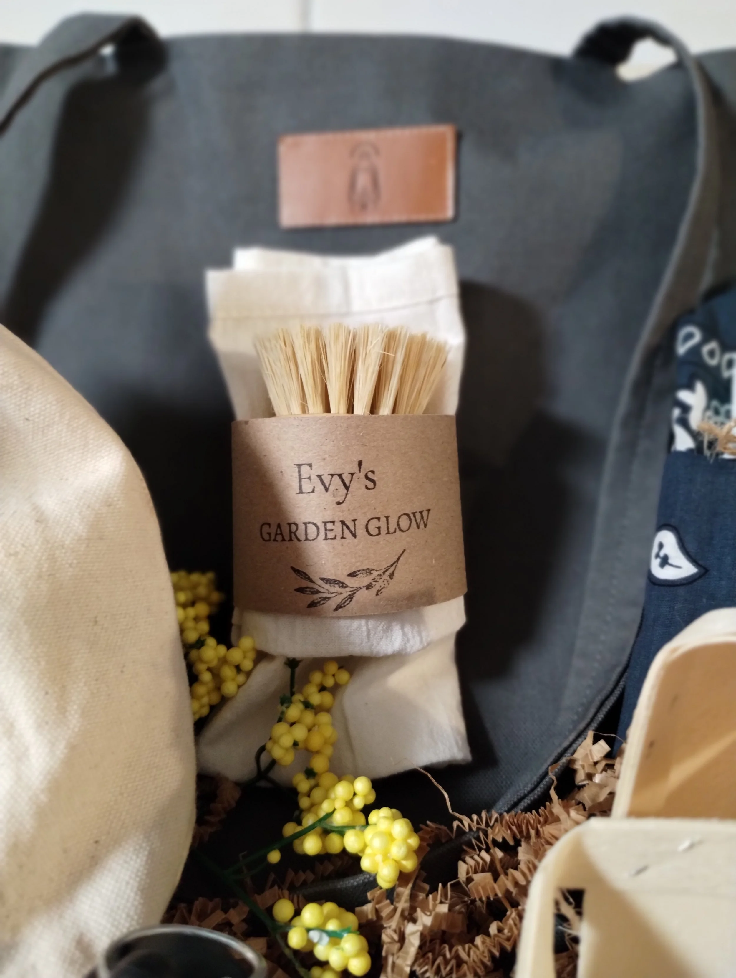 Handmade produce cloth and natural bristle scrubber wrapped with an Evy’s Garden Glow paper band.