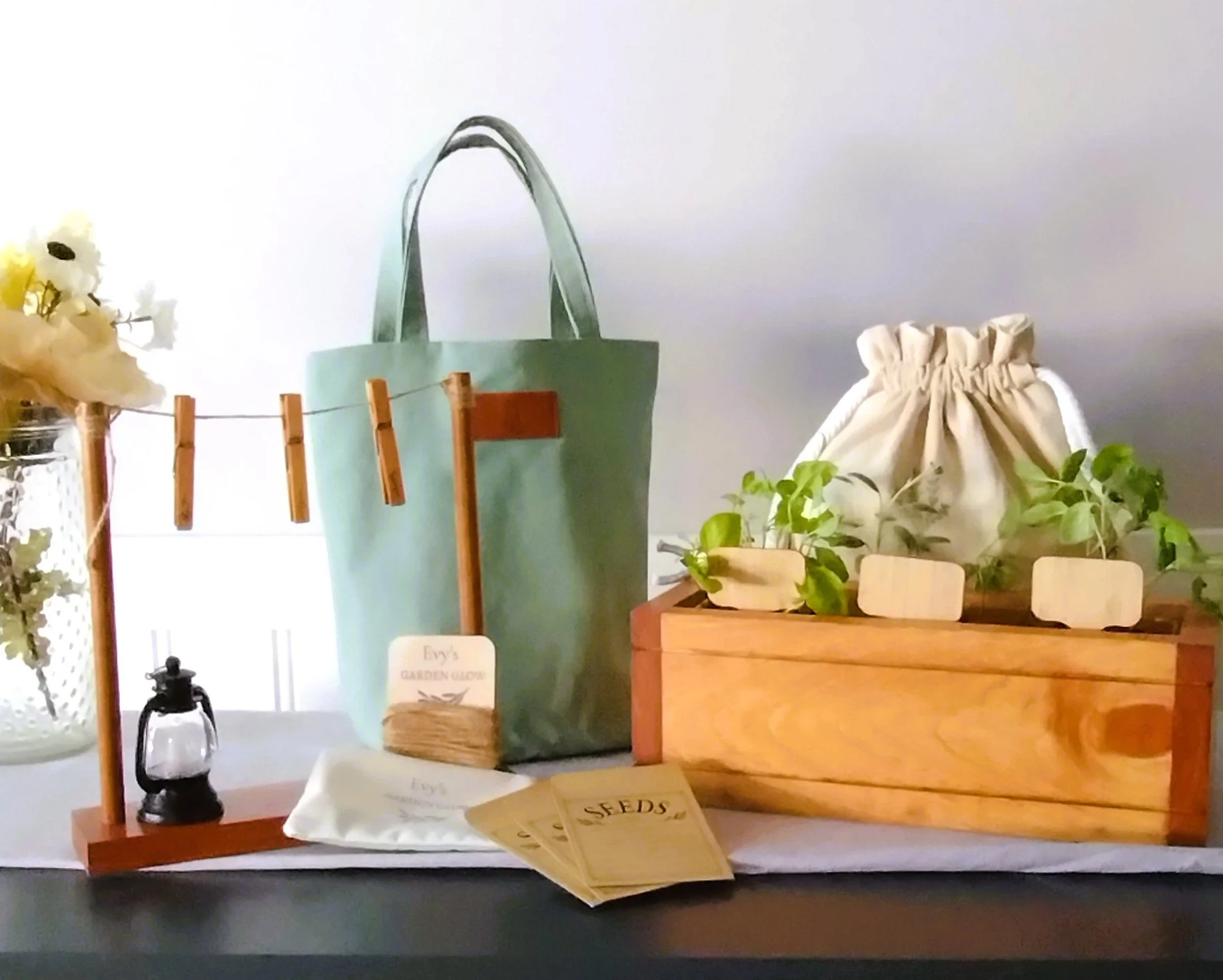Herb Garden Gift Box with sage green canvas tote, wooden planter, herb drying rack, seed envelopes, plant markers, drawstring bag, and mini lantern.