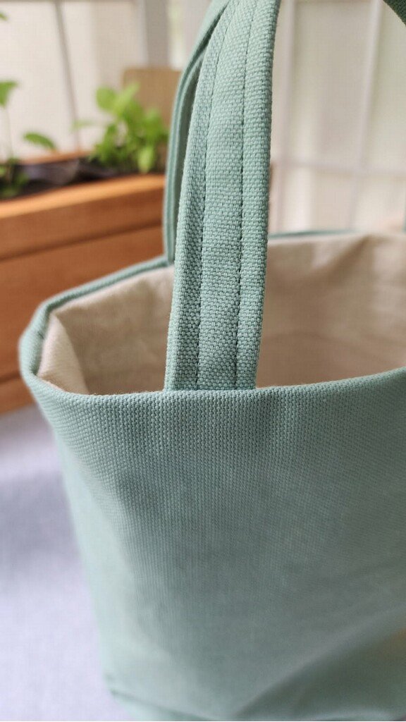 Sage green bag tote close up of handles and stitching