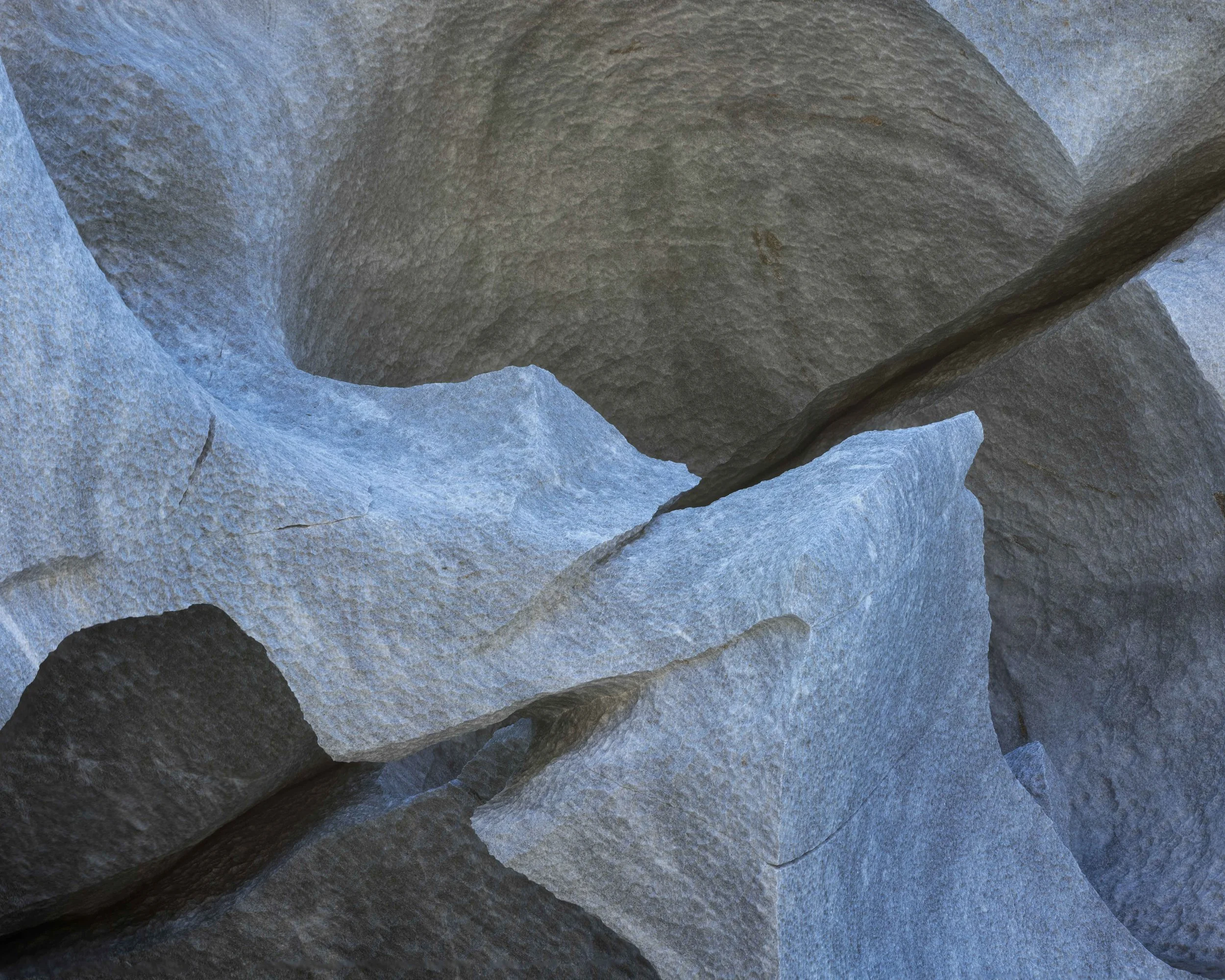 Fotografía abstracta de rocas con tonos azules y grises, formas orgánicas y textura mineral, ideal para representar detalles naturales y geológicos.