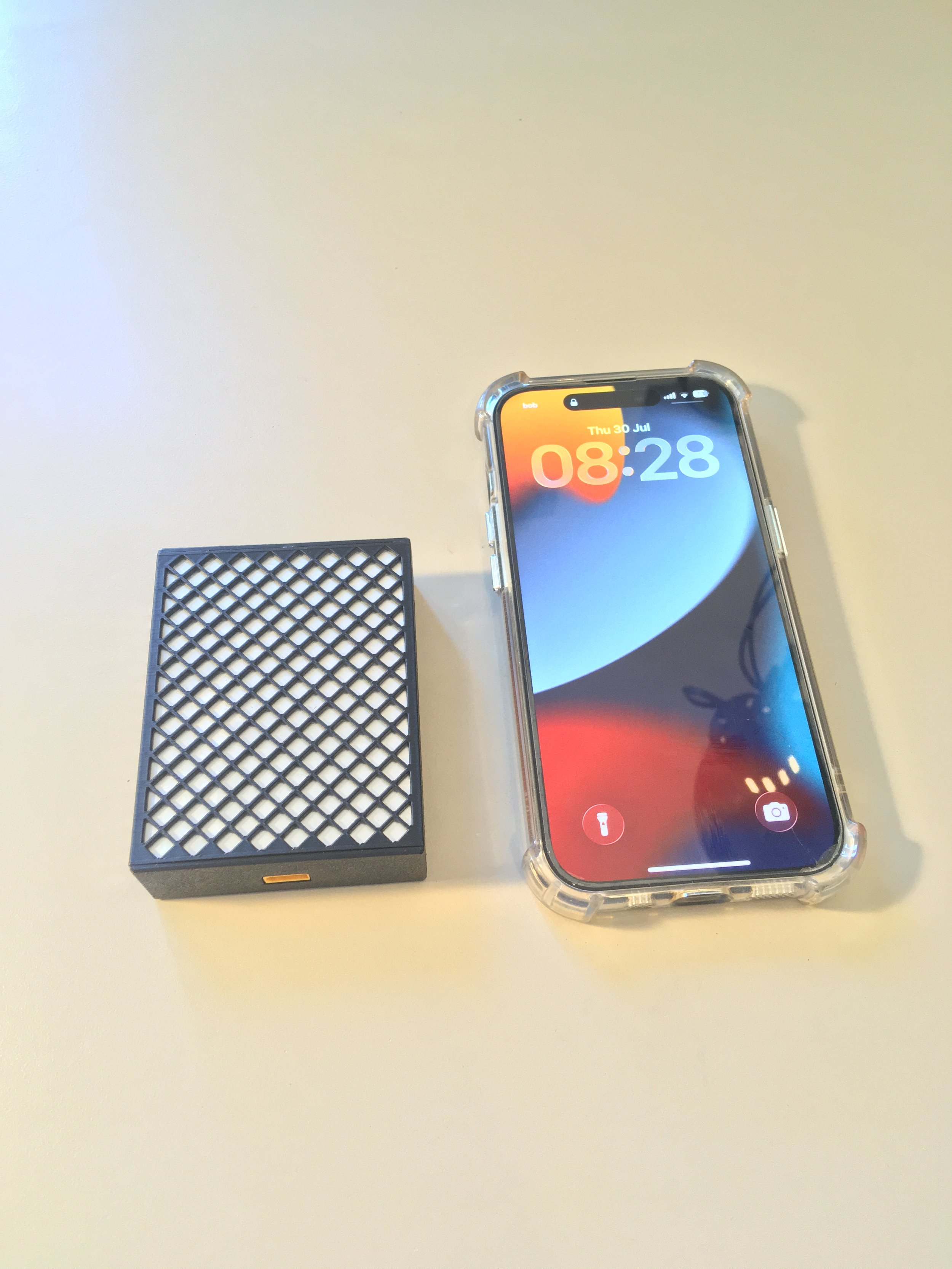 A TravelWatt user comparing the size of TravelWatt with his iPhone.