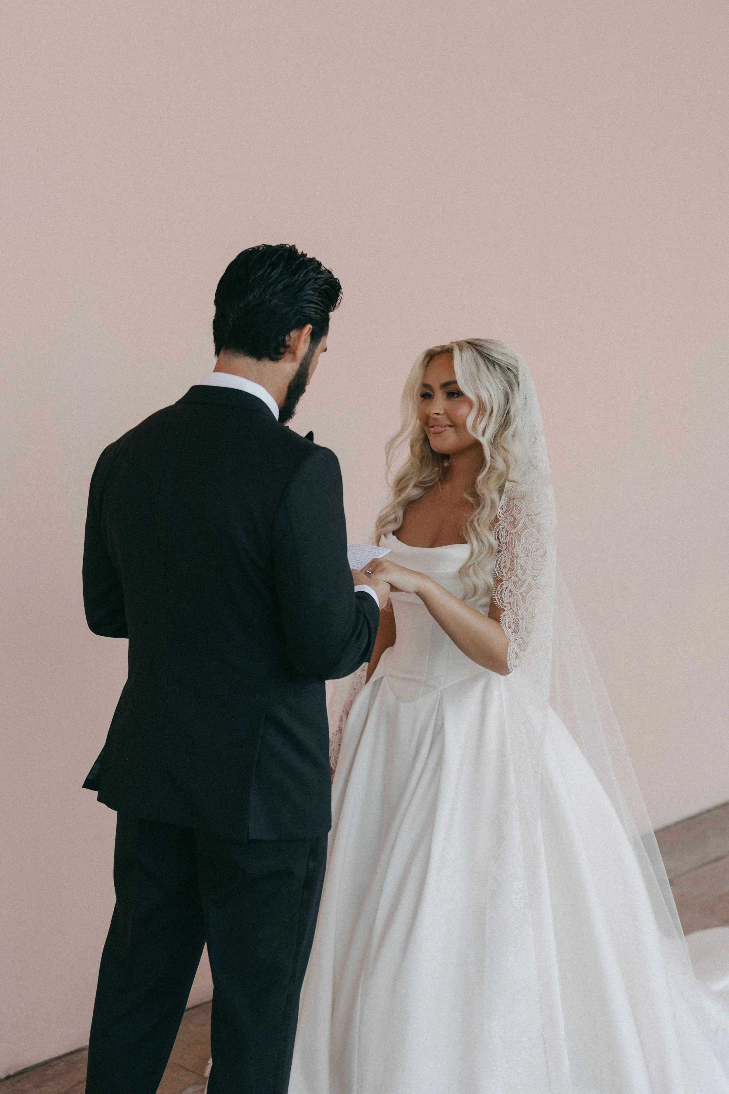 A bride and groom exchanging rings during their wedding ceremony.