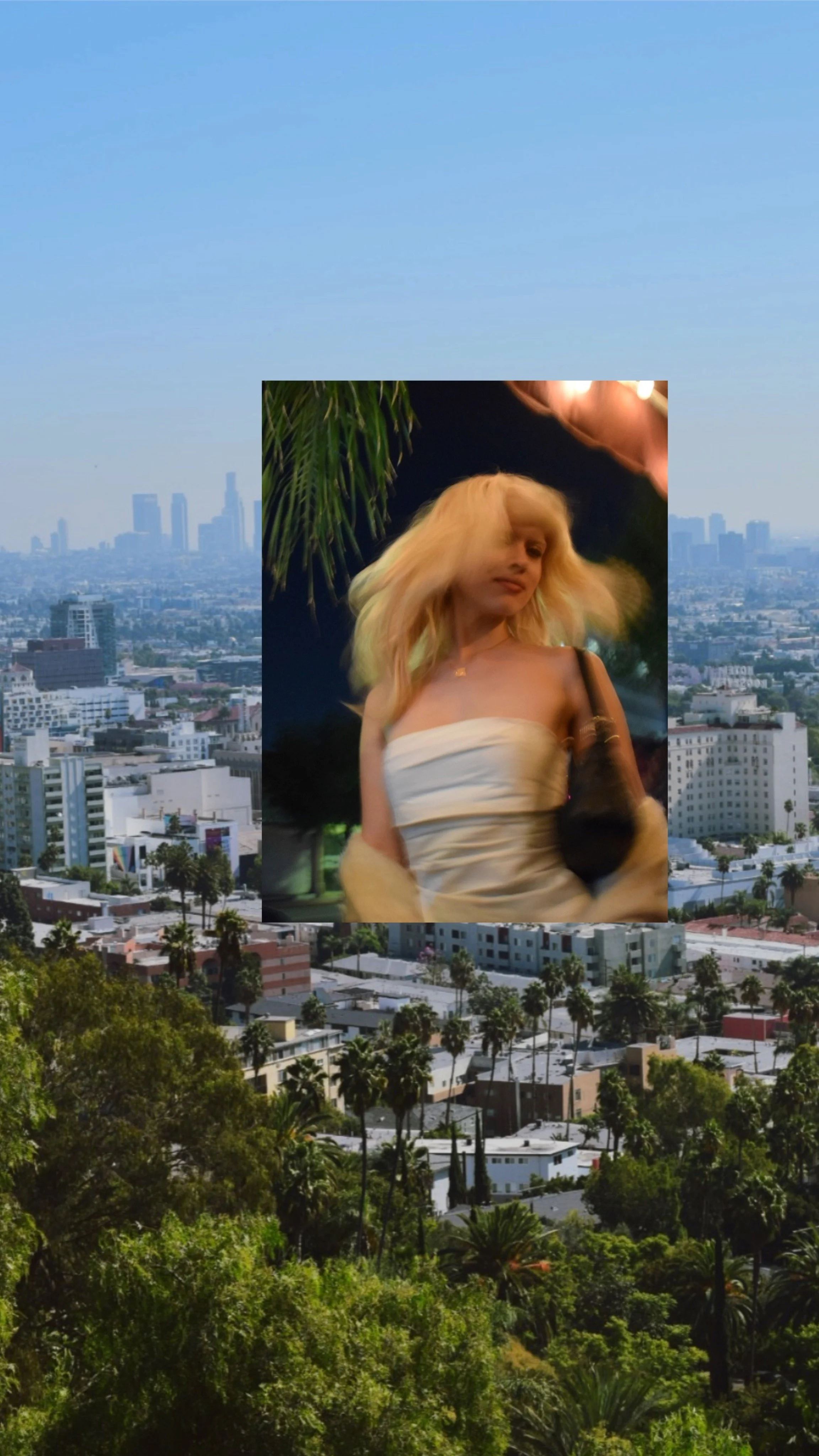 A cityscape with tall buildings and trees in the foreground, with a smaller inset photo of a woman with blonde hair in a strapless beige top, standing outdoors at night near a palm tree.