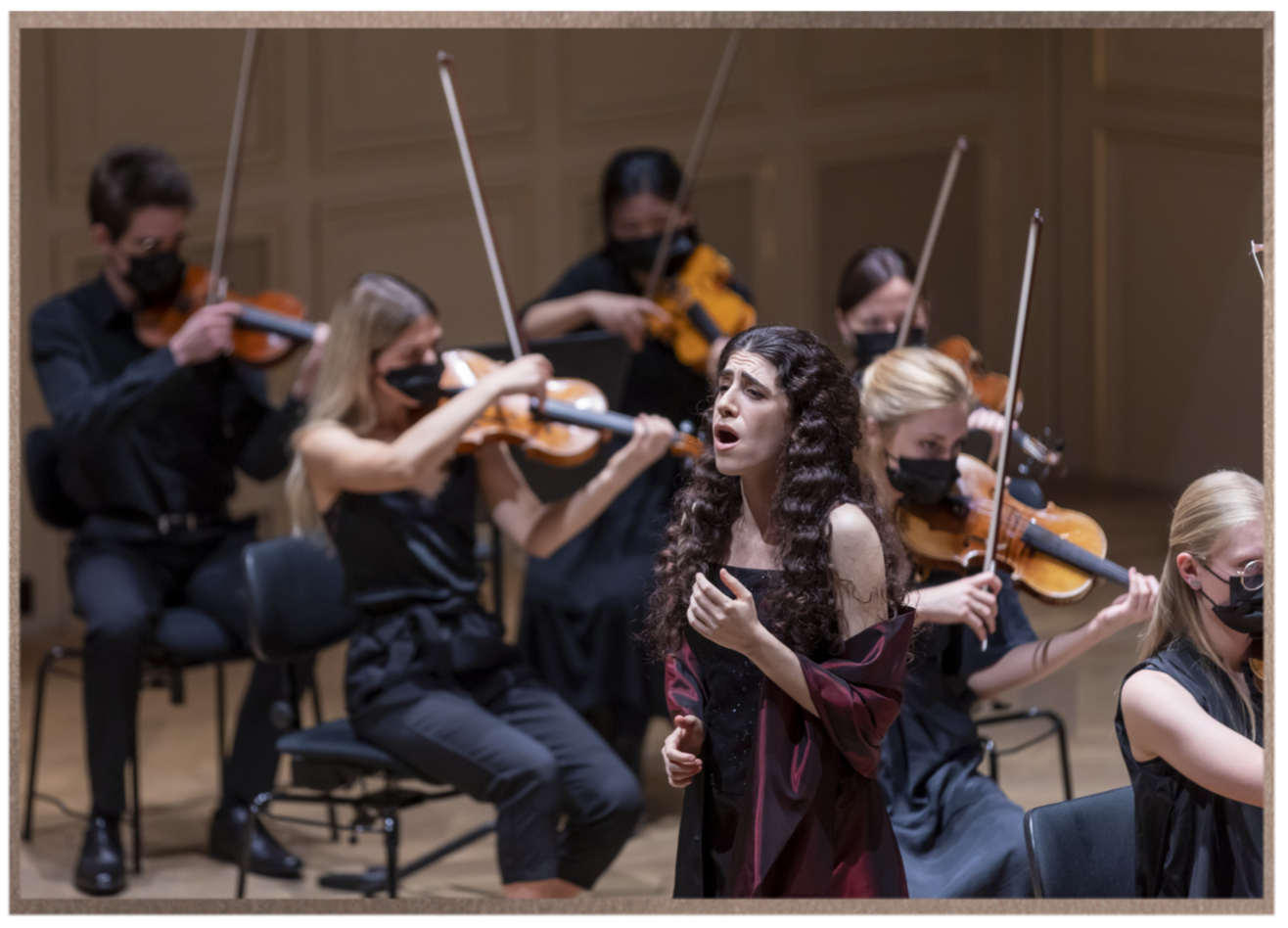 Adi Denner singing with orchestra during a live classical performance.