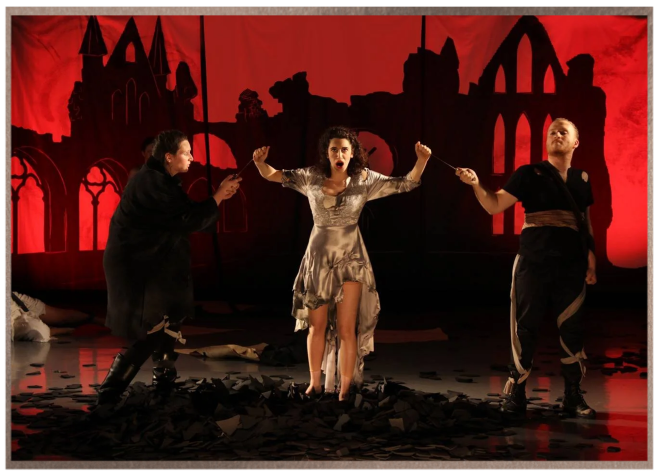 Adi Denner in a dramatic operatic confrontation against a crimson stage backdrop.