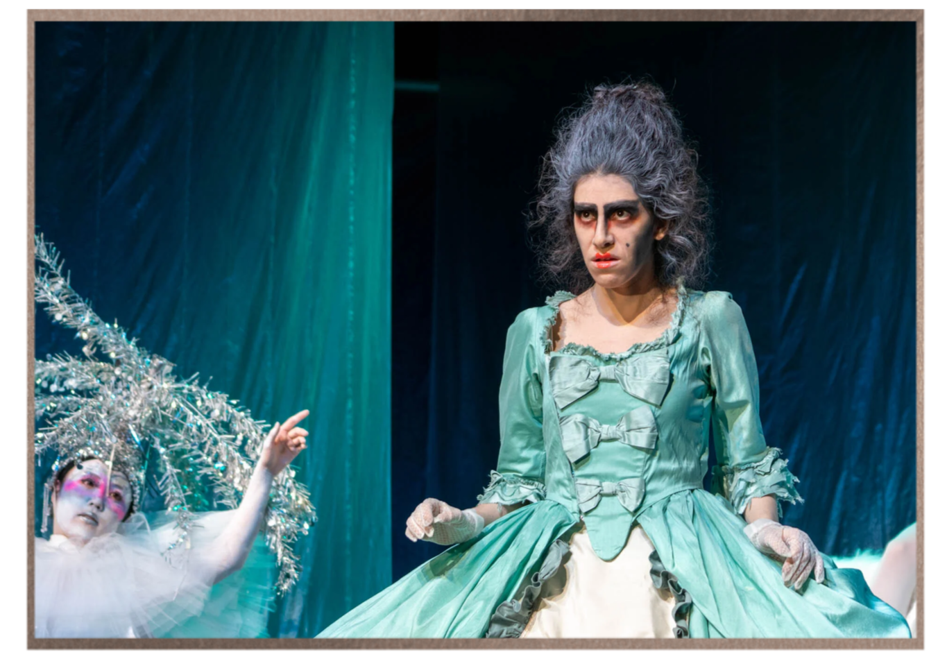Adi Denner portraying a dramatic operatic character in period costume and makeup.