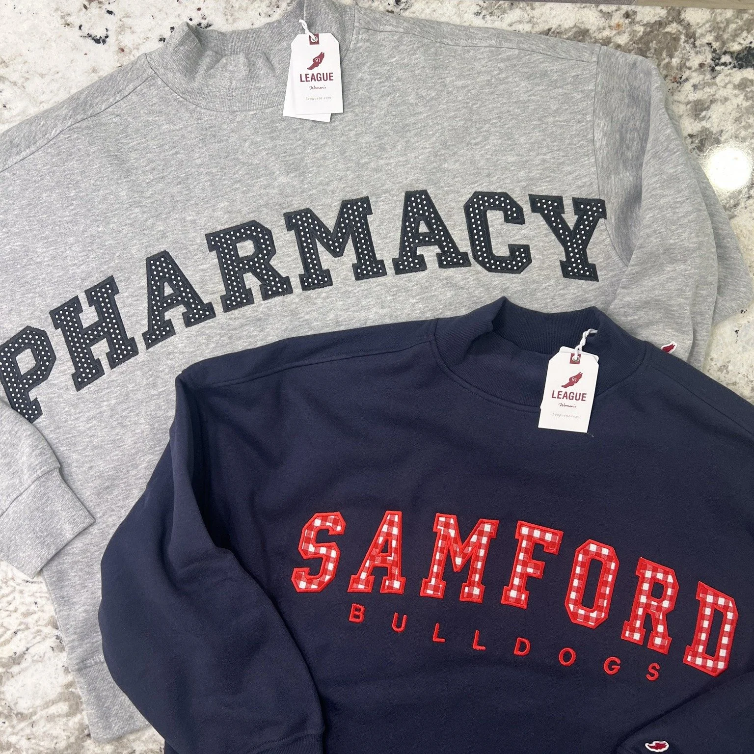 Two ways to wear your pride 🐾 A varsity "Pharmacy" pullover for the future PharmDs and a Samford Bulldogs crew with gingham lettering for game day. Big block letters are one of our favorite techniques &mdash; they hold up beautifully wash 