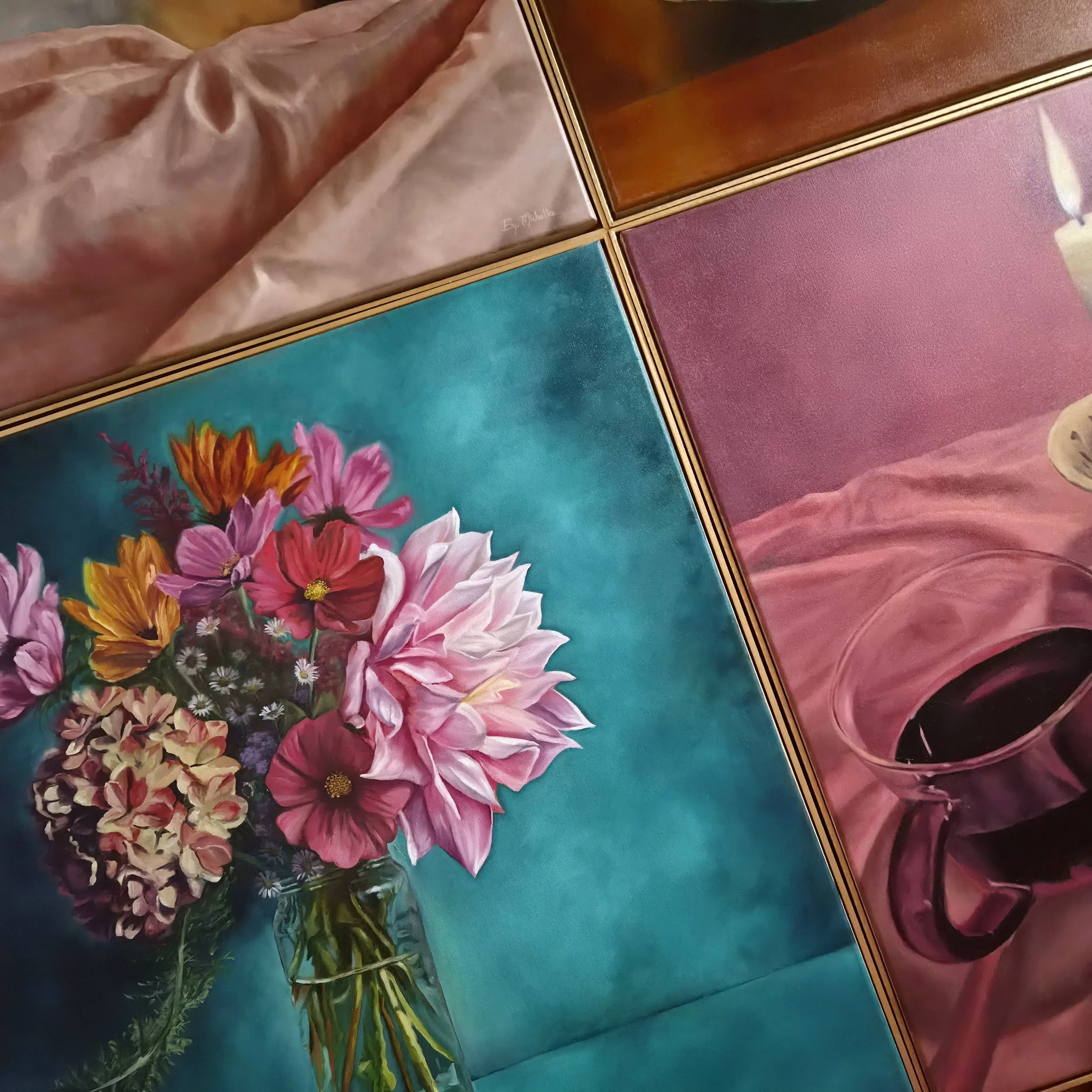 A bouquet of pink, orange, white, and purple flowers in a glass vase on a table with a turquoise tablecloth, with a pink curtain behind it.