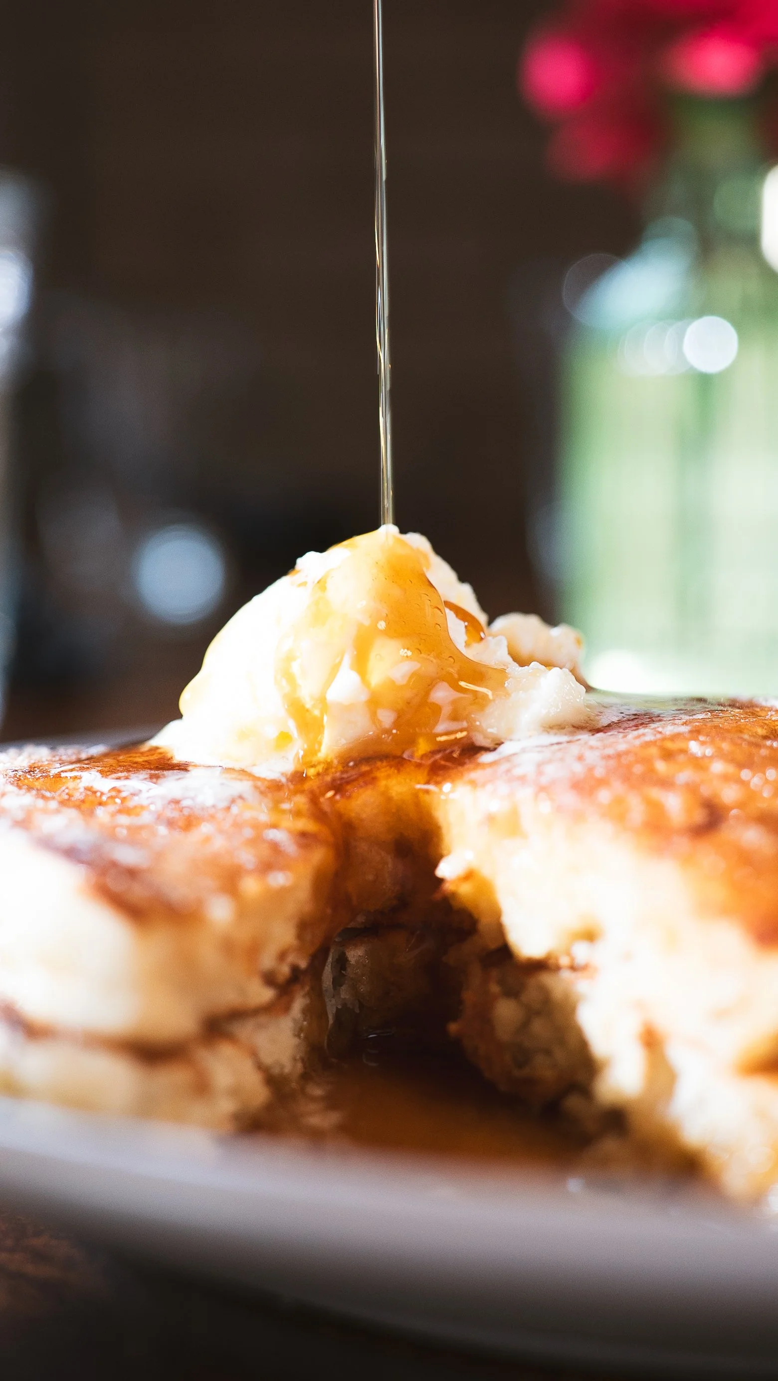 A close-up of syrup drizzled on pancakes made from scratch. 